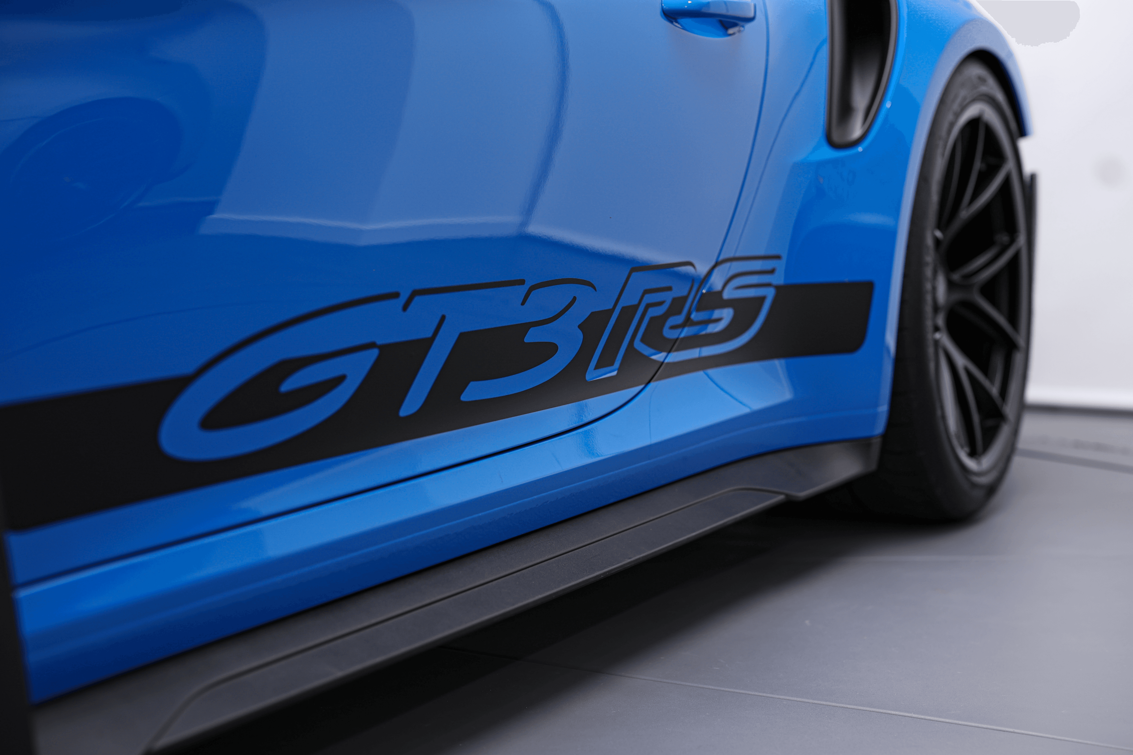 Focus sur le logo GT3RS sur le flanc de la Porsche shark blue, une marque distinctive qui souligne son identité de supercar haute performance.