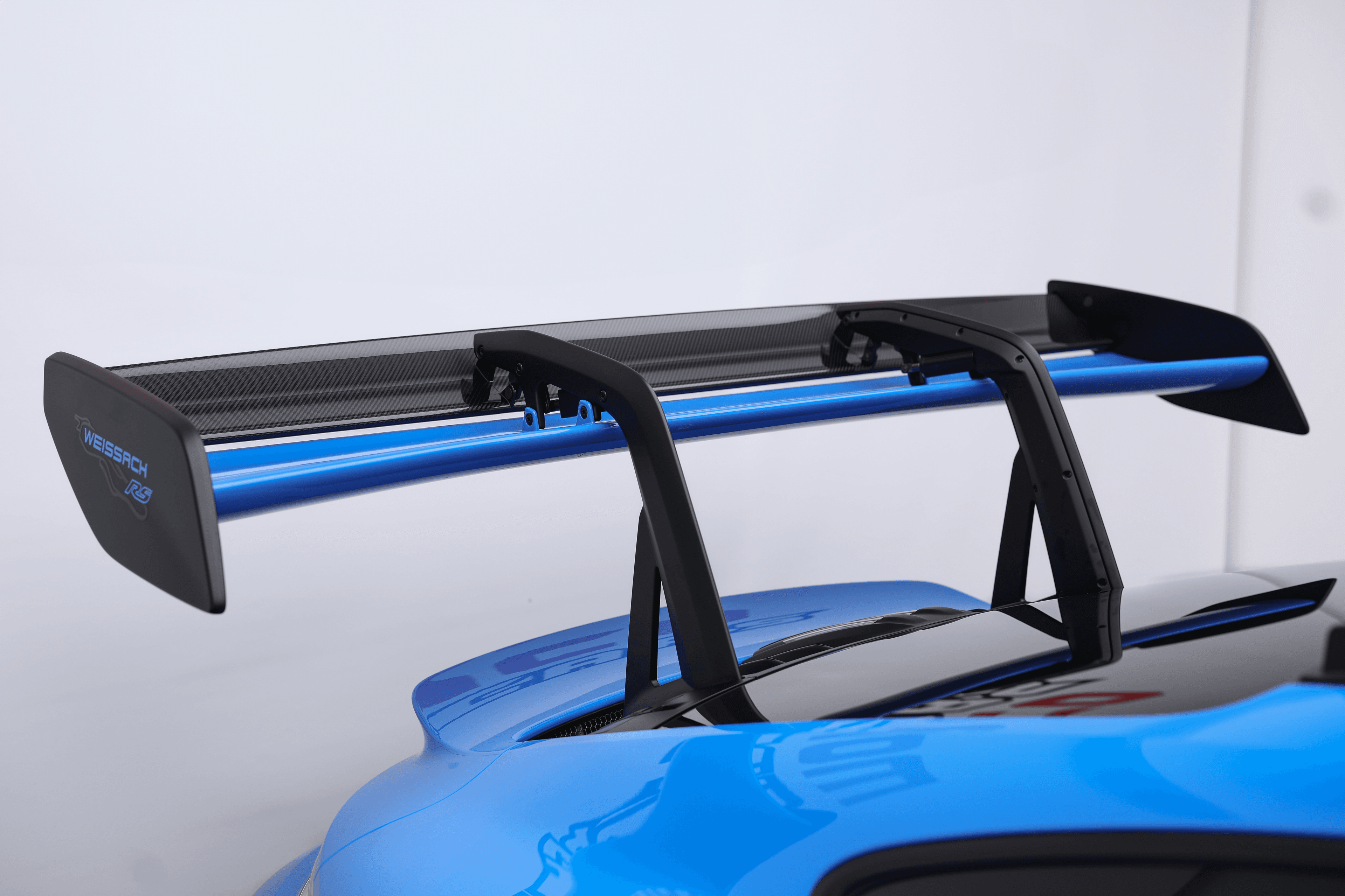 Vue détaillée de l'aileron arrière de la Porsche GT3RS bleue, conçu pour maximiser l'aérodynamisme et offrir une performance optimale sur piste.