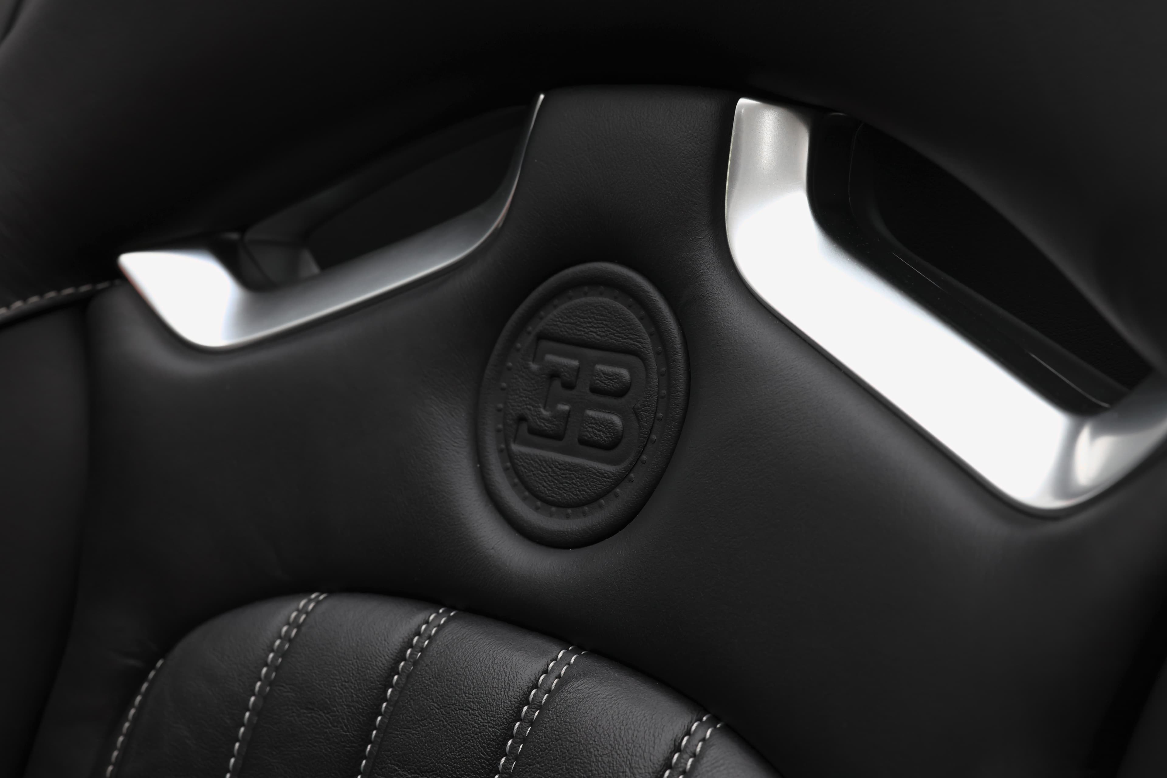 À l'intérieur, le siège en cuir de la Bugatti Veyron arbore fièrement le logo gravé, symbolisant l'exclusivité et le luxe, tout en ajoutant une touche d'élégance à cet habitacle raffiné.