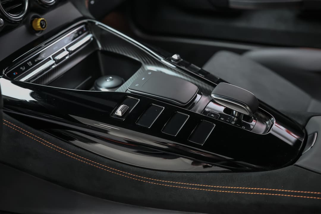 Explorez la console centrale de notre AMG Black Series, mettant en avant des surpiqûres orange qui ajoutent une touche dynamique et sportive, tout en intégrant des fonctionnalités modernes pour une expérience de conduite exceptionnelle. Disponible dans notre showroom à Monaco.