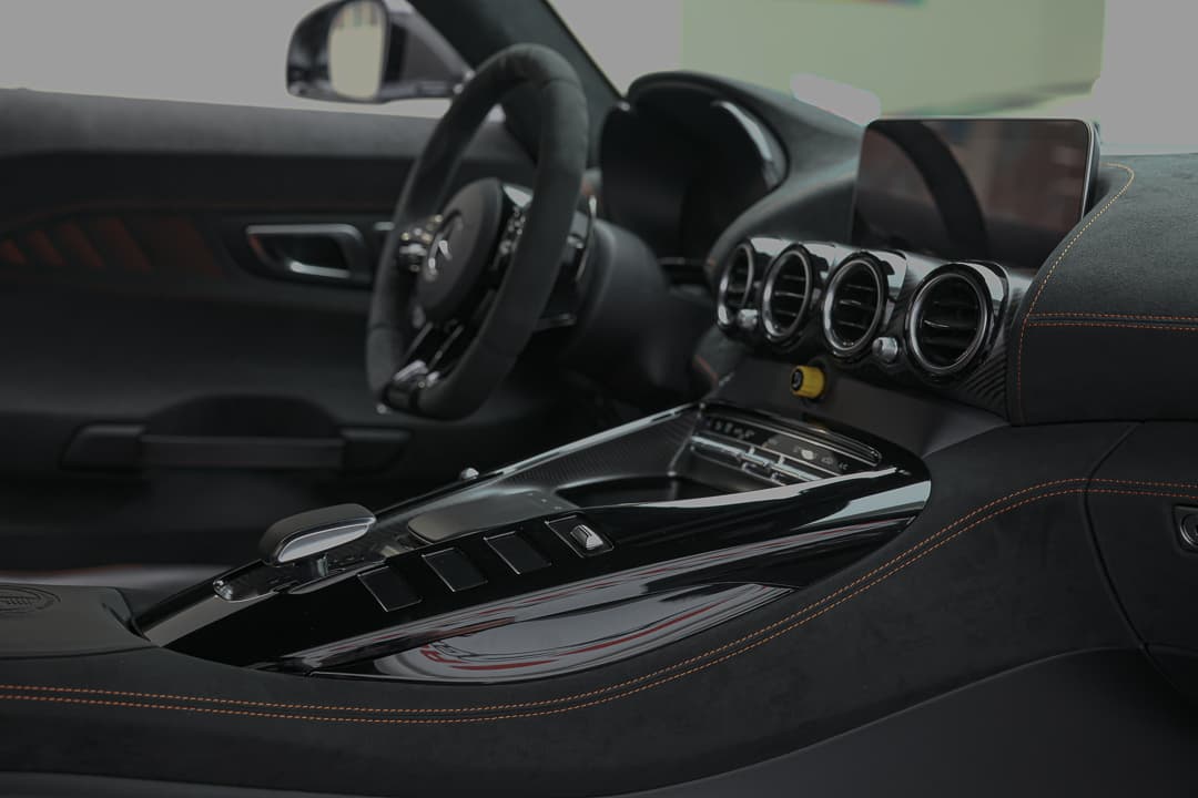 Explorez l'intérieur de notre AMG Black Series avec une vue sur la console centrale et le volant. Chaque élément est conçu pour allier performance et esthétique, offrant un cockpit sportif où chaque trajet devient une expérience inoubliable. Disponible dans notre showroom à Monaco.