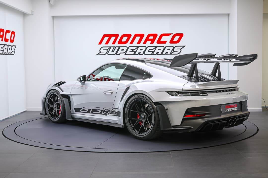 Cette vue en trois quarts arrière de la Porsche 911 GT3 RS révèle son design distinctif, avec son aileron proéminent et ses lignes agressives, tout en mettant en avant le charme de son arrière sculpté qui incarne la performance et l'élégance.