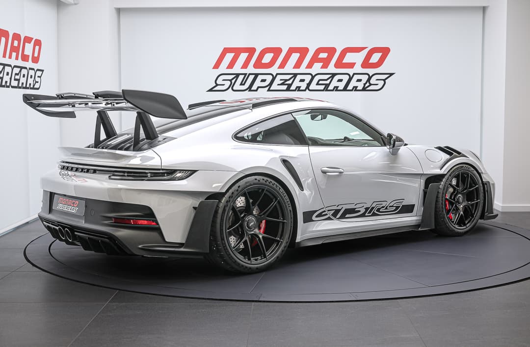 Cette vue en trois quarts arrière de la Porsche 911 GT3 RS révèle son design distinctif, avec son aileron proéminent et ses lignes agressives, tout en mettant en avant le charme de son arrière sculpté qui incarne la performance et l'élégance.