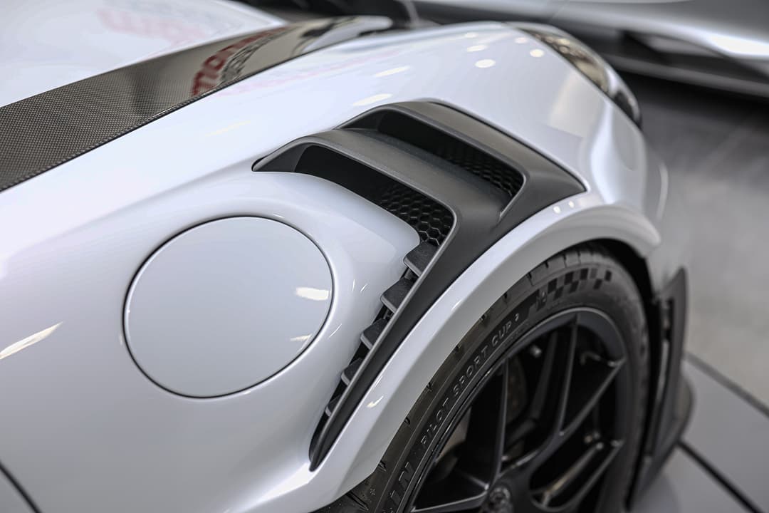 Cette image met en avant le système d'aération des freins de la Porsche 911 GT3 RS, conçu pour optimiser la gestion de la température et améliorer l'adhérence, tout en soulignant l'importance de chaque détail dans la quête de performance sur circuit.