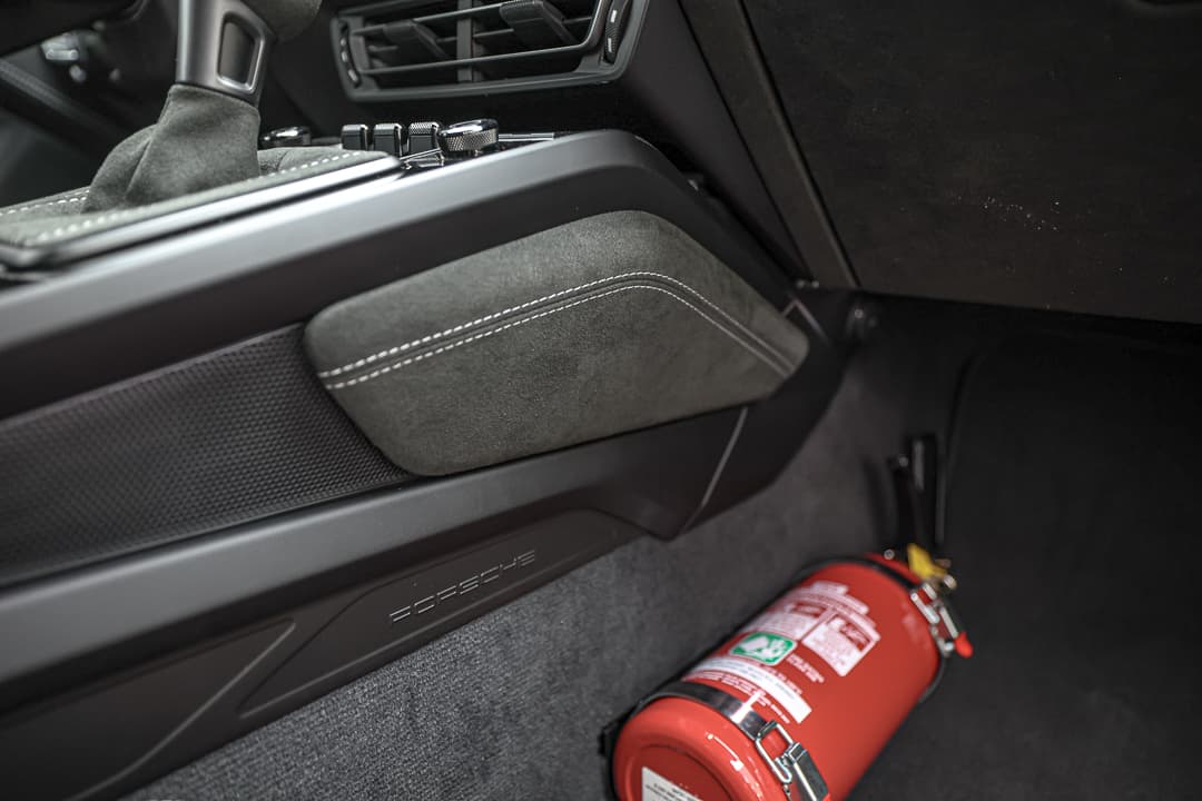 Voici une phrase pour décrirCette image de la console centrale de la Porsche 911 GT3 RS met en avant une disposition ergonomique, avec des commandes sportives, des finitions en carbone et une technologie de pointe, créant un espace fonctionnel et stylé qui place le conducteur au cœur de l'expérience de conduite.