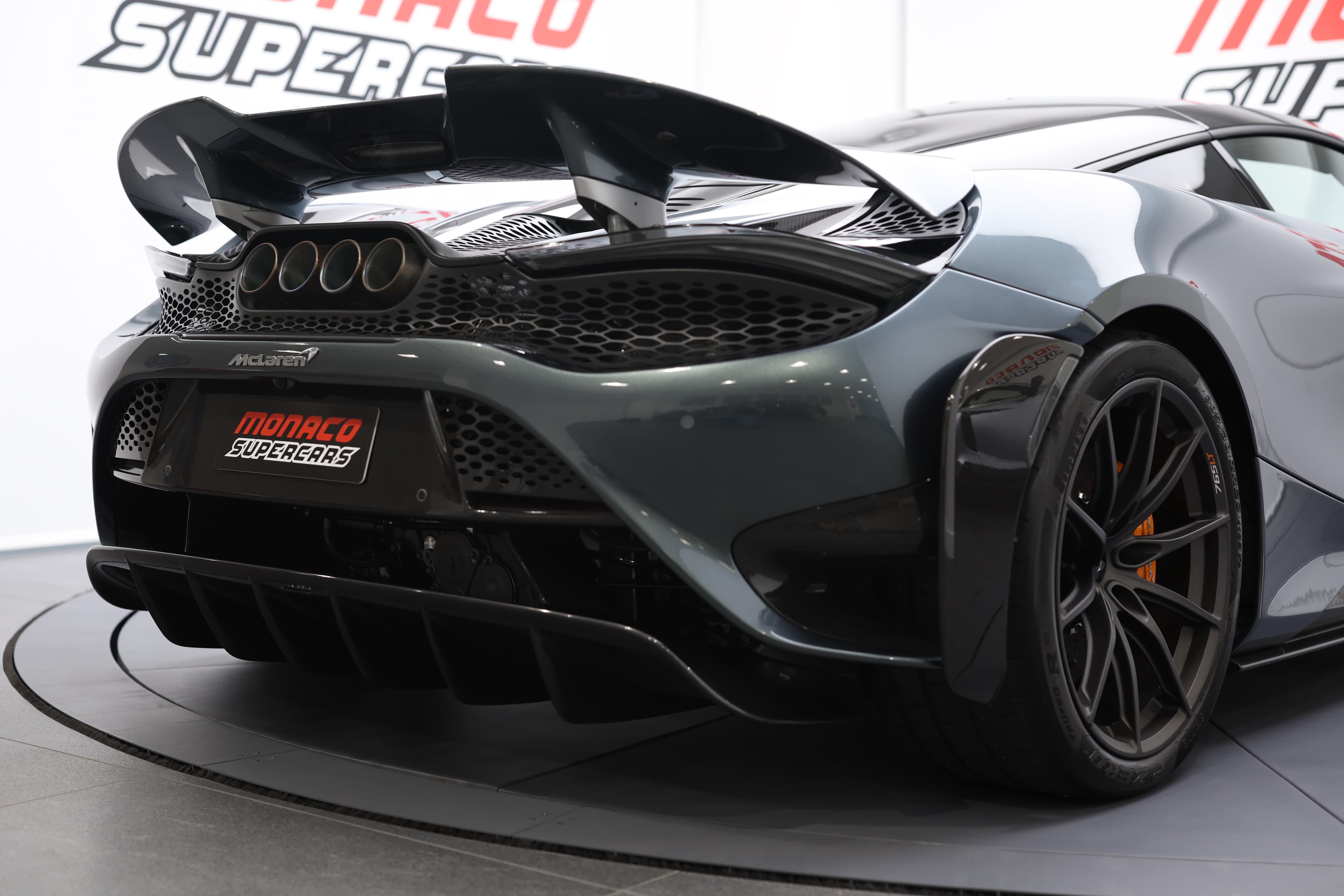 L'image met en avant le diffuseur arrière de la McLaren 765LT, soulignant son design complexe et fonctionnel, qui améliore l'aérodynamisme et l'appui, tout en ajoutant une touche agressive à l'arrière de la voiture.