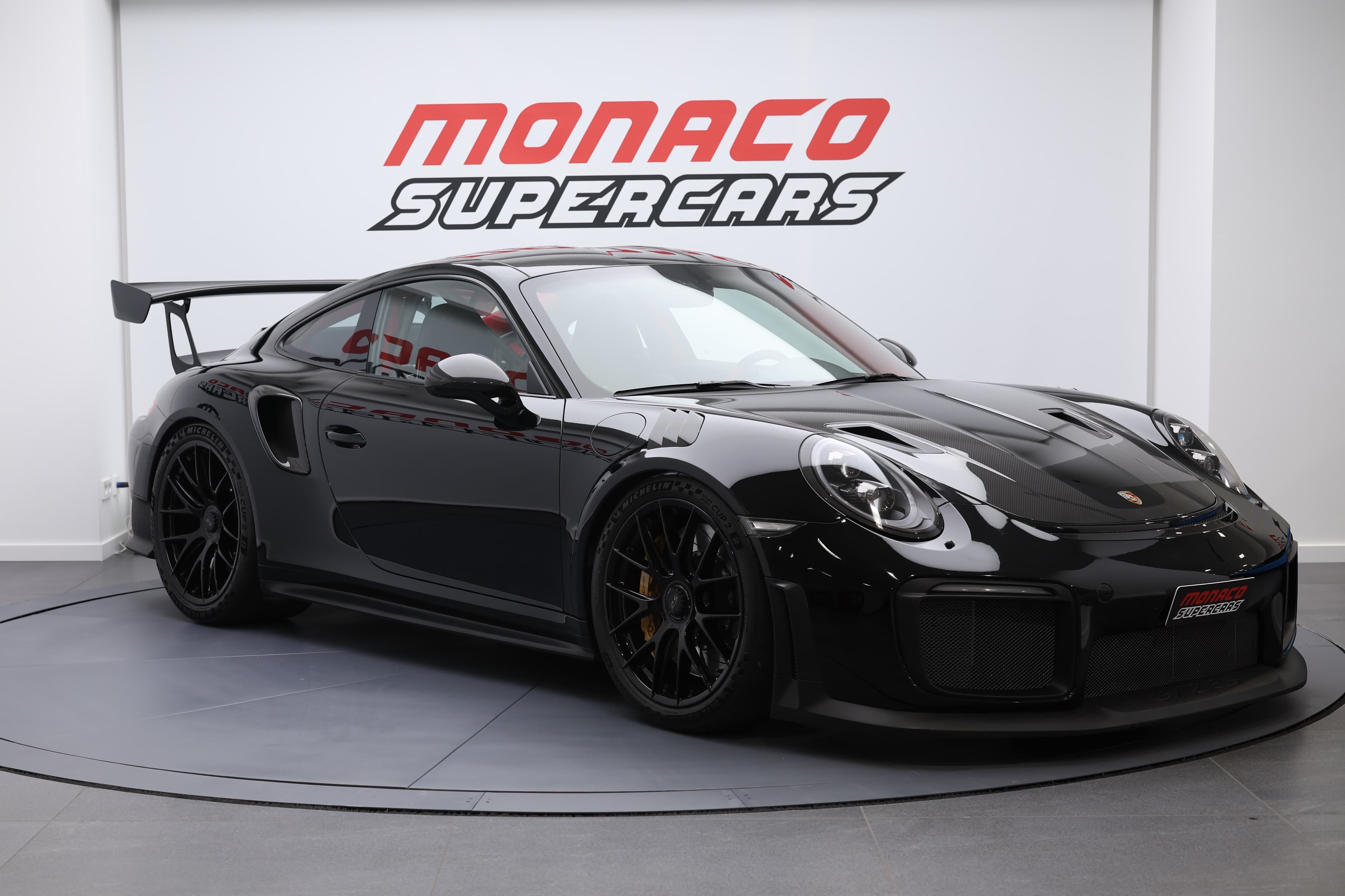 À vendre, Porsche 911 GT2 RS noire, vue 3/4 avant, supercar de luxe, performances exceptionnelles, design aérodynamique, moteur puissant, traction arrière, Monaco, collection exclusive.