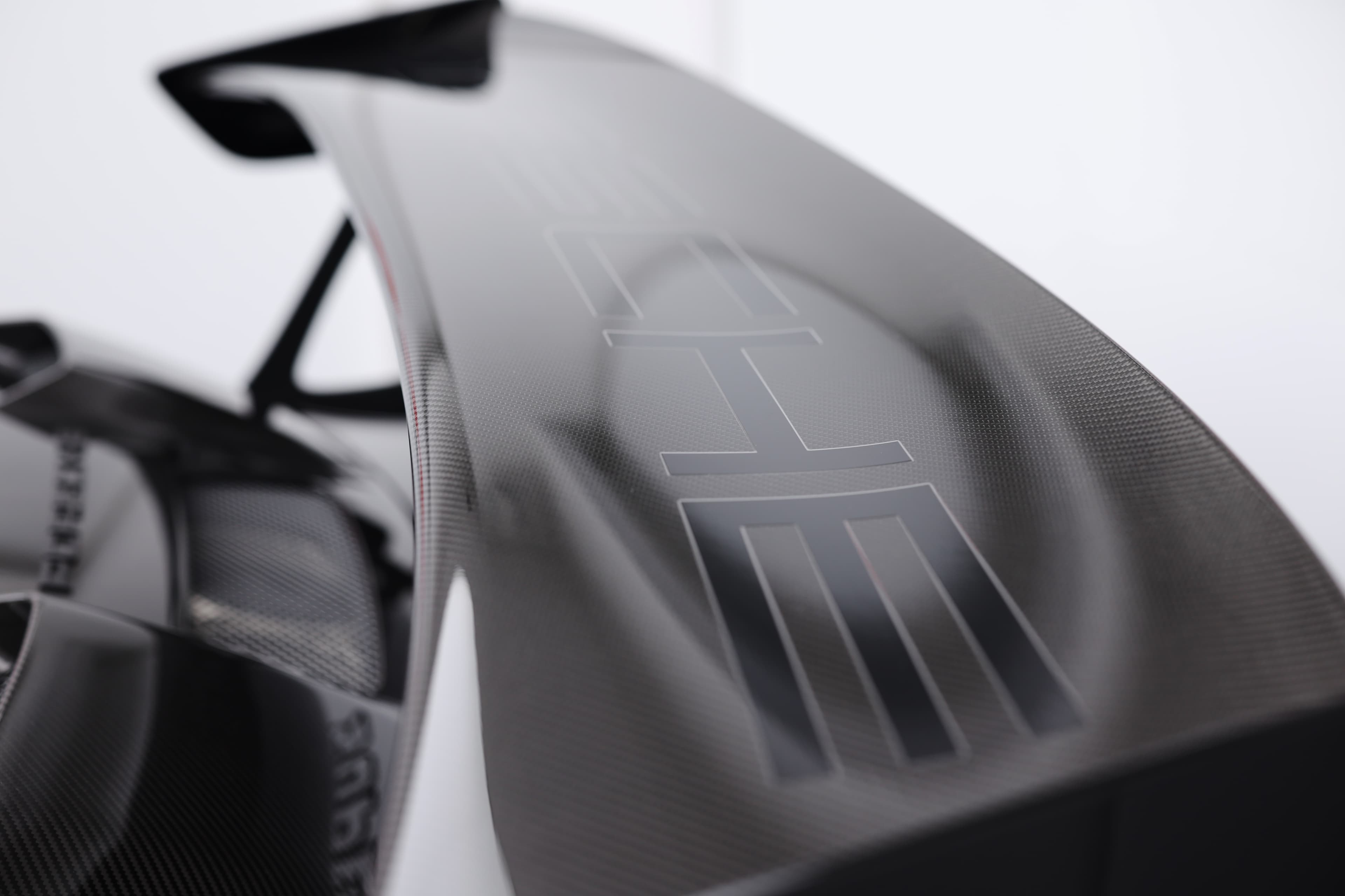 Photo de l'aileron de la Porsche 911 GT2 RS noire, mettant en avant son design aérodynamique et sportif, essentiel pour la performance de cette supercar.