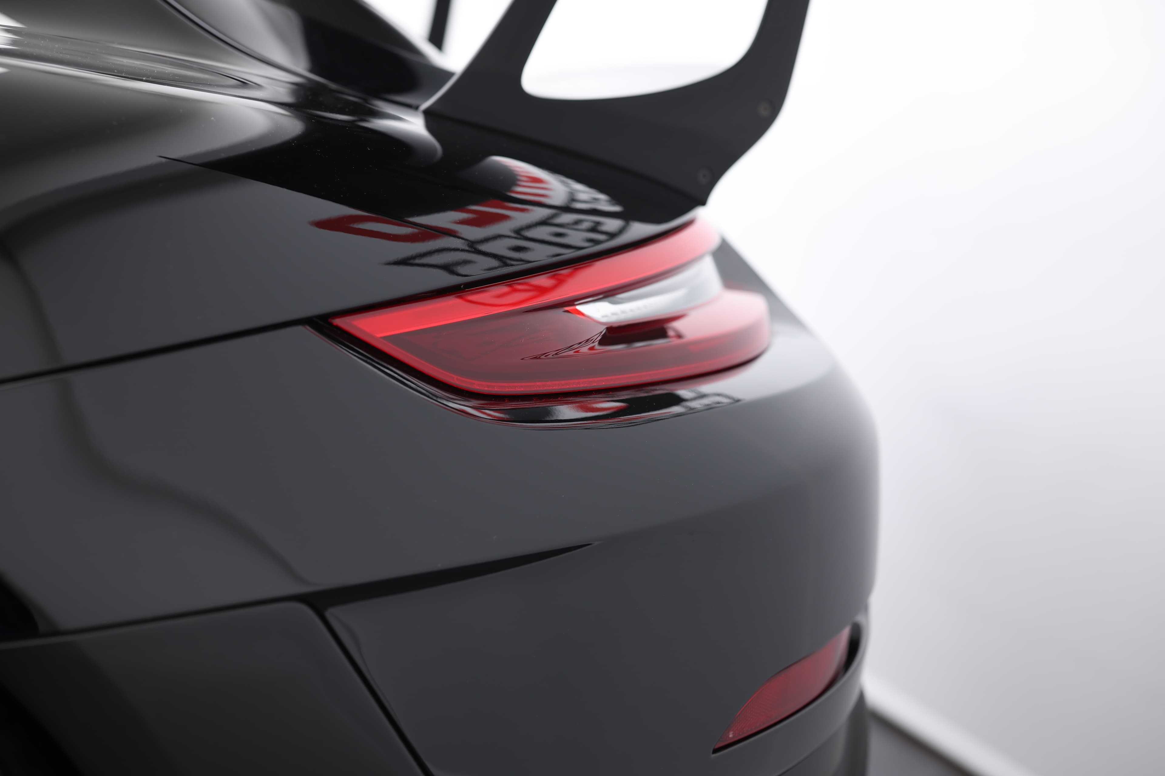 Image des feux arrière de la Porsche 911 GT2 RS noire, soulignant leur esthétique agressive et leur technologie LED avancée, ajoutant une touche de sophistication et d'agilité.