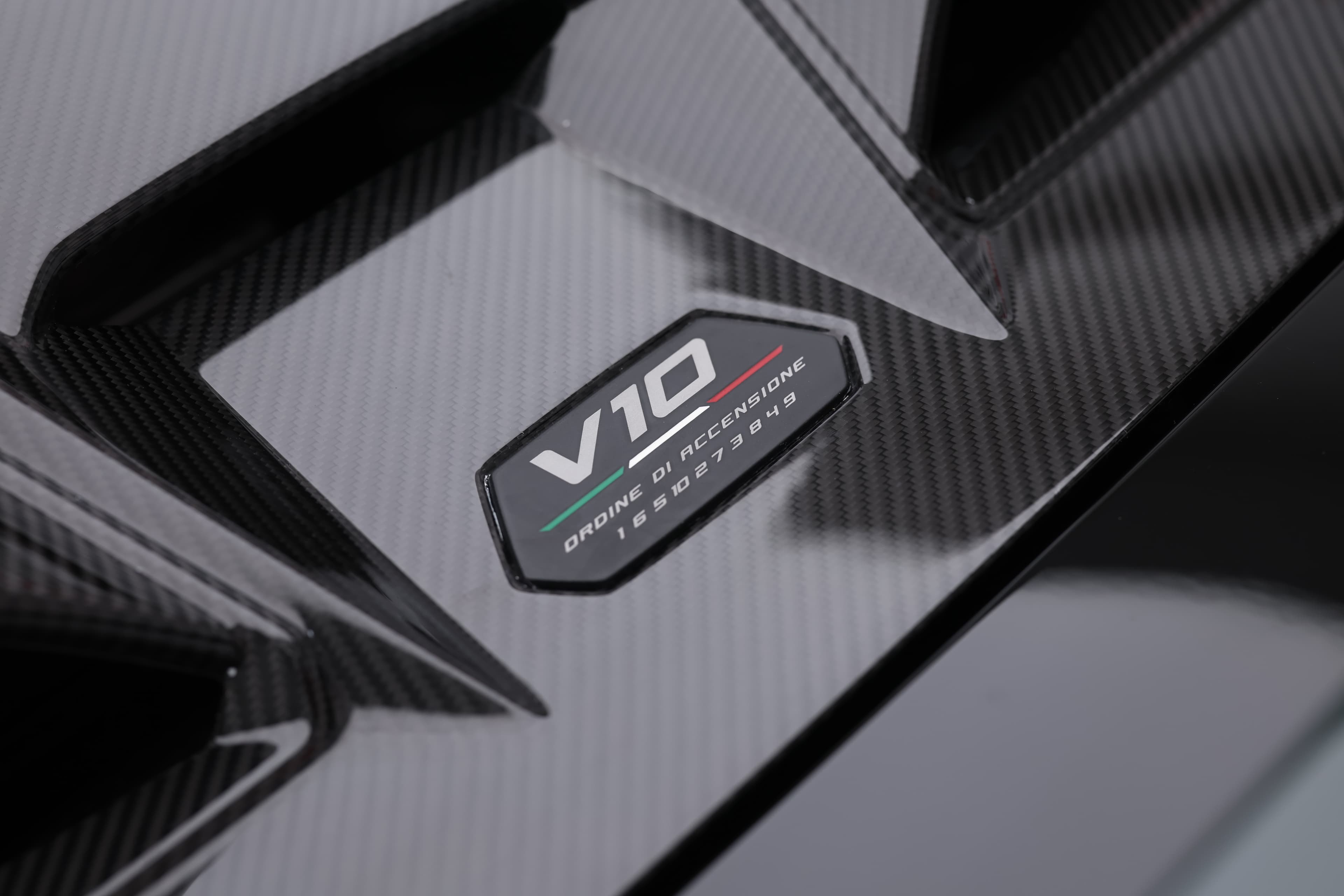 La plaque moteur de la Lamborghini Huracán Tecnica, affichant fièrement "V10", souligne la puissance brute et l'ingénierie de précision qui font de cette supercar un véritable bijou sur routes.