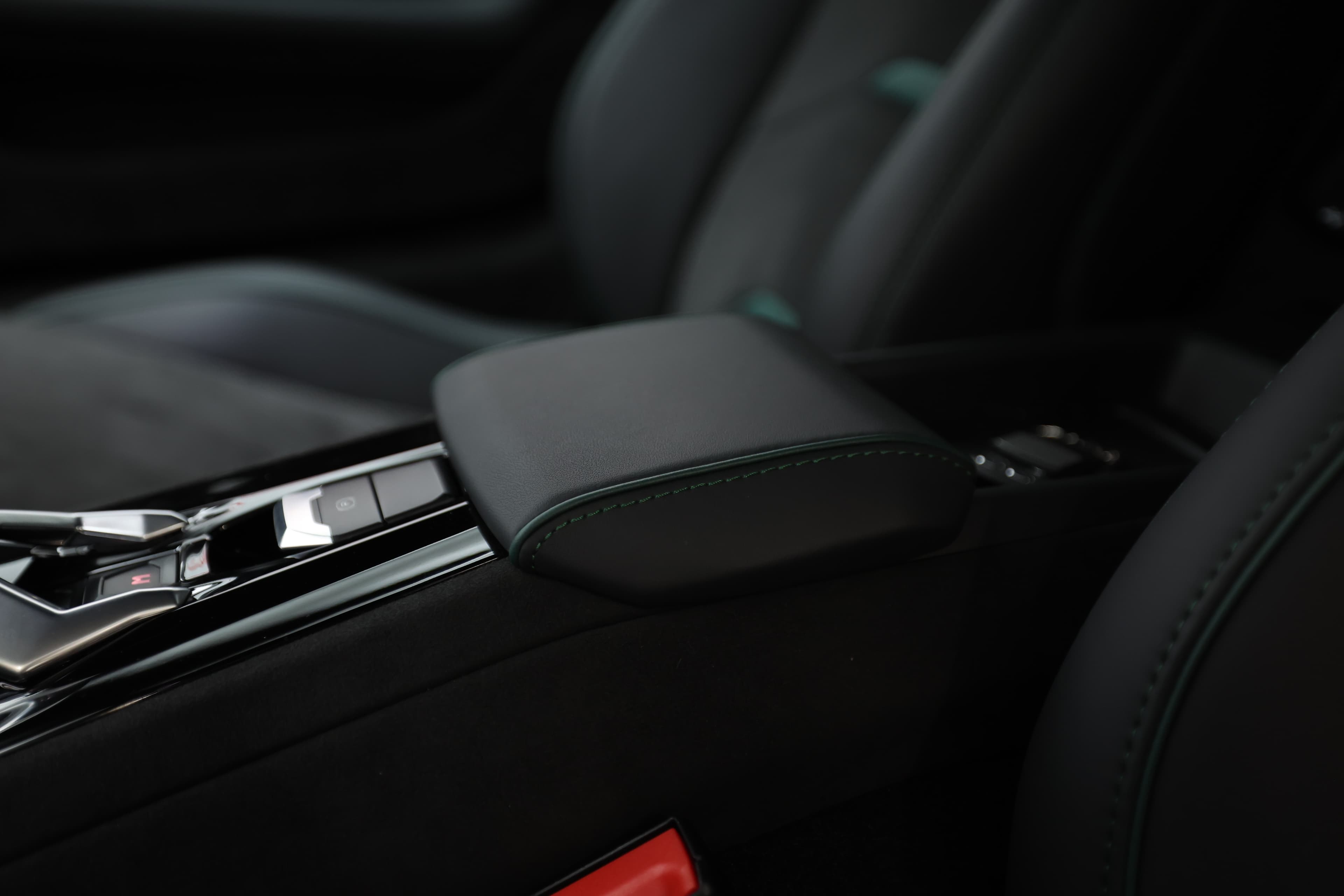 L'accoudoir de la Lamborghini Huracán Tecnica, revêtu de cuir et Alcantara, présente des surpiqûres raffinées qui ajoutent une touche d'élégance, tout en offrant confort et accessibilité pour une expérience de conduite premium.