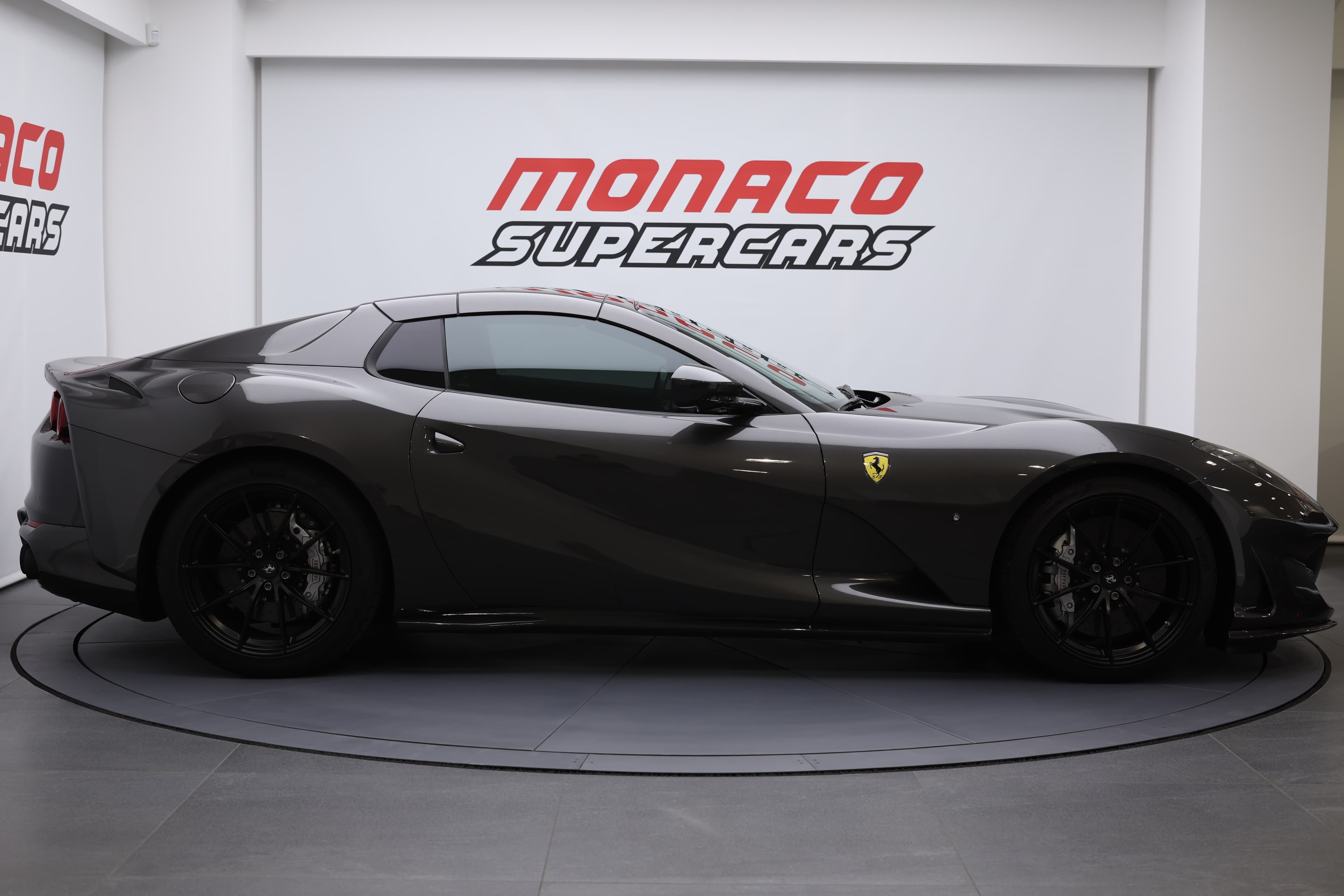 La vue de profil de la Ferrari 812 GTS dévoile ses courbes élégantes et sa silhouette dynamique, accentuant l'aérodynamisme et la puissance de son moteur V12, tout en reflétant l'esprit sportif et le luxe caractéristique de la marque.