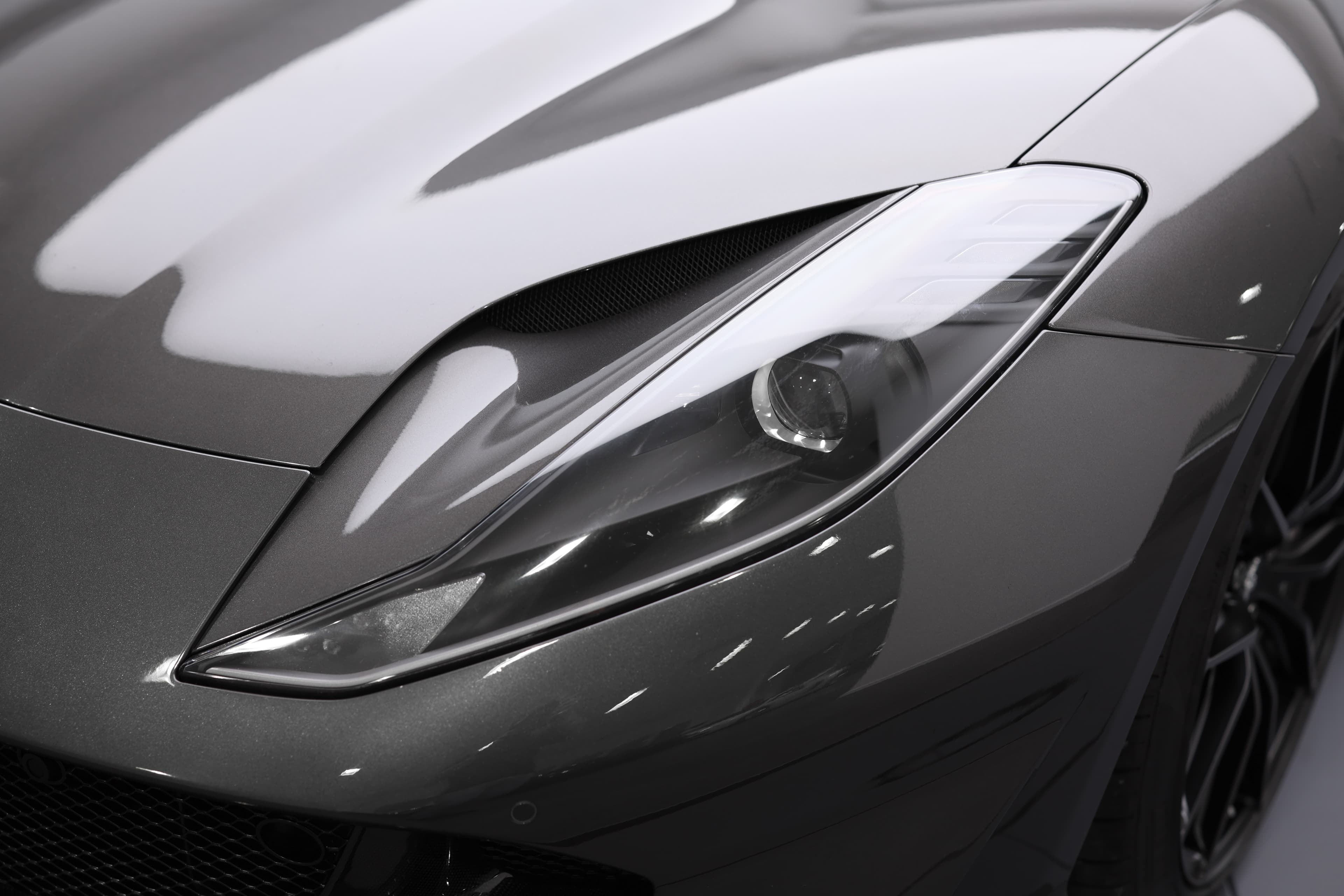 Les feux avant de la Ferrari 812 GTS, au design agressif et anguleux, intègrent des technologies LED avancées, soulignant son caractère dynamique tout en assurant une visibilité optimale.