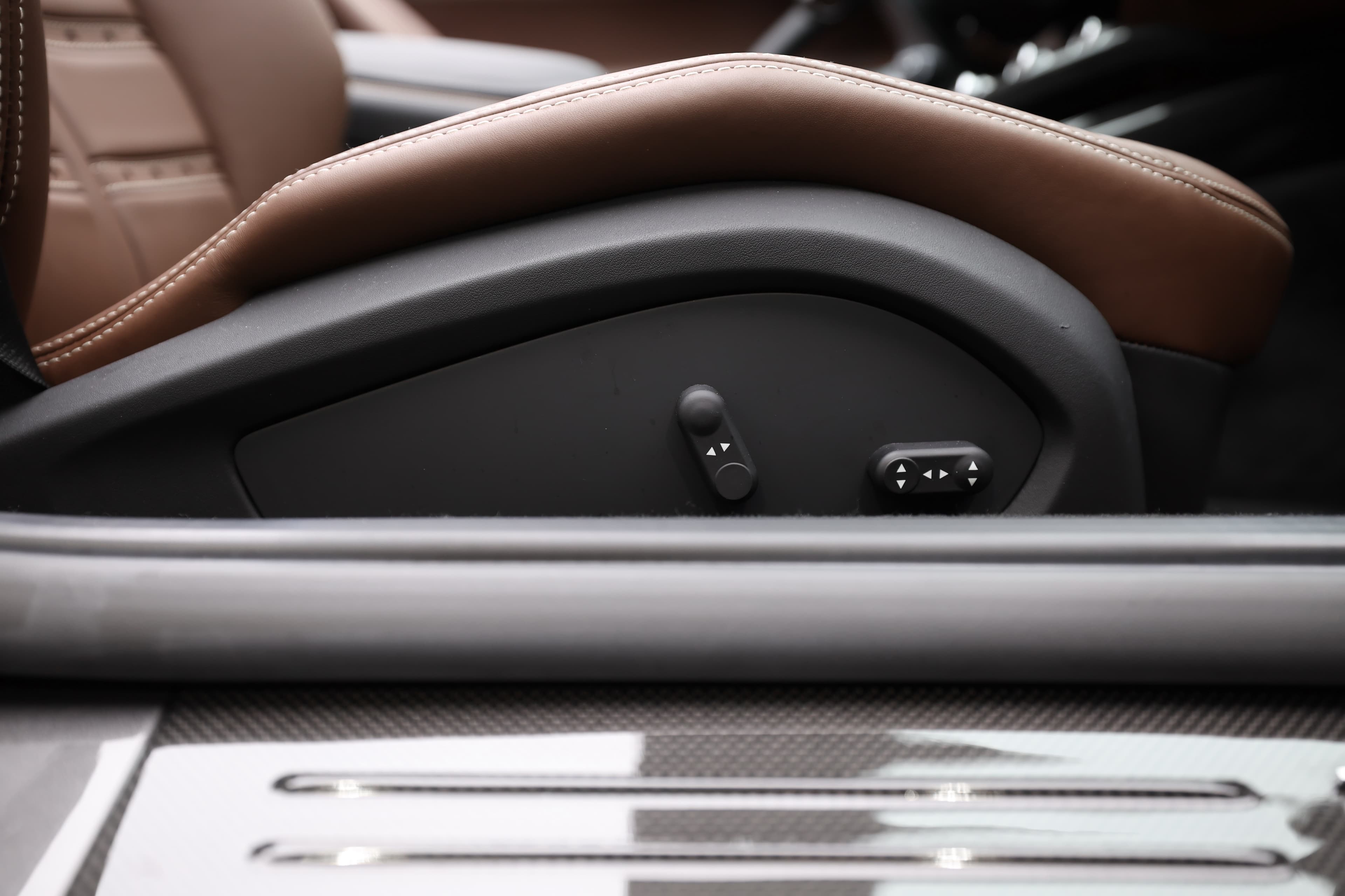 Examinez le système de réglage des sièges de la Ferrari 812 GTS, alliant fonctionnalité et élégance. Les commandes intégrées, discrètes et intuitives, permettent d'ajuster facilement la position pour un confort optimal, tout en maintenant l'esthétique raffinée de l'intérieur en cuir chocolat.