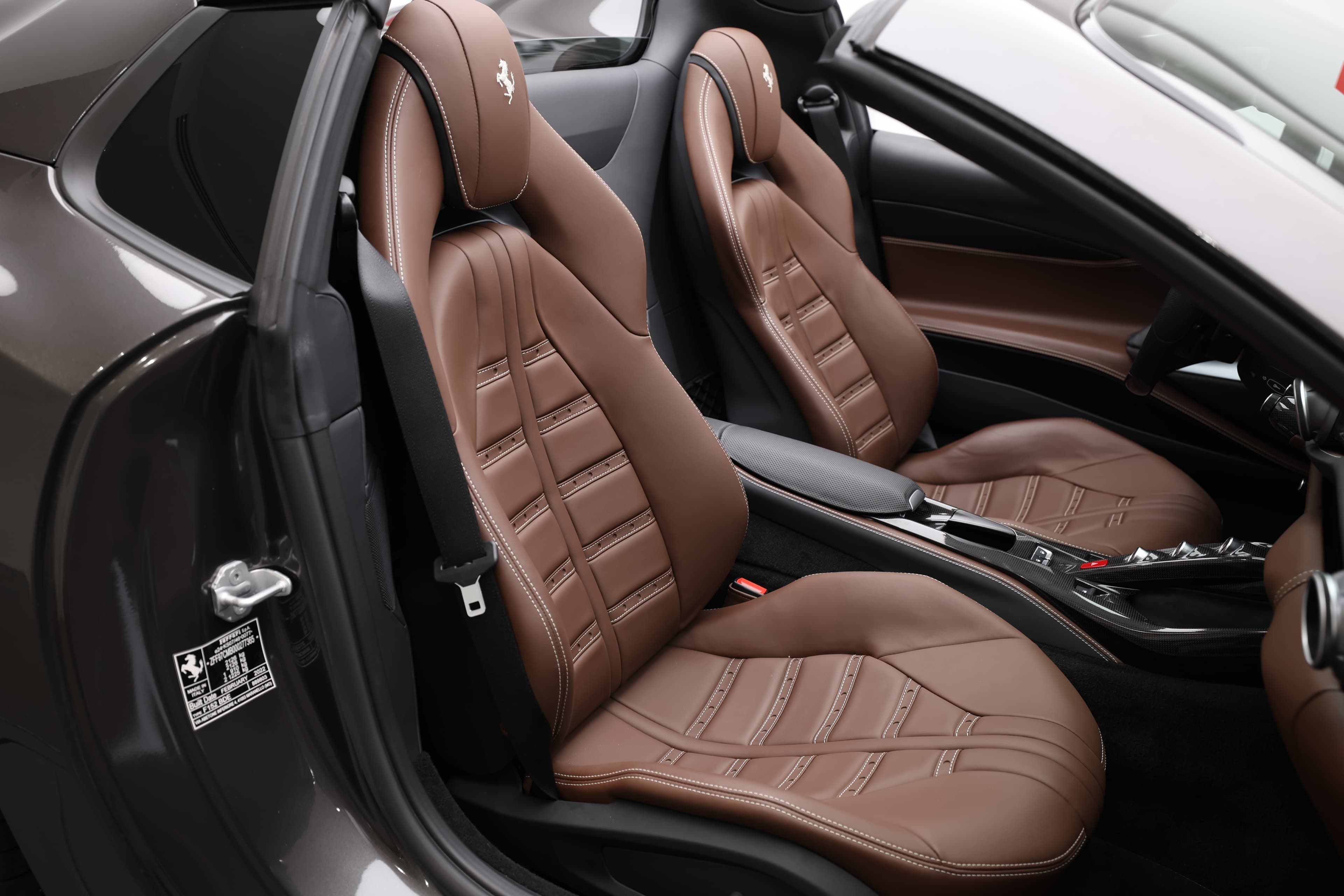 Appréciez les sièges sportifs de la Ferrari 812 GTS, soigneusement conçus pour offrir un confort optimal tout en maintenant une allure dynamique. Le cuir chocolat et les motifs de couture raffinés ajoutent une touche de sophistication, renforçant l'engagement de Ferrari envers l'excellence dans chaque détail.