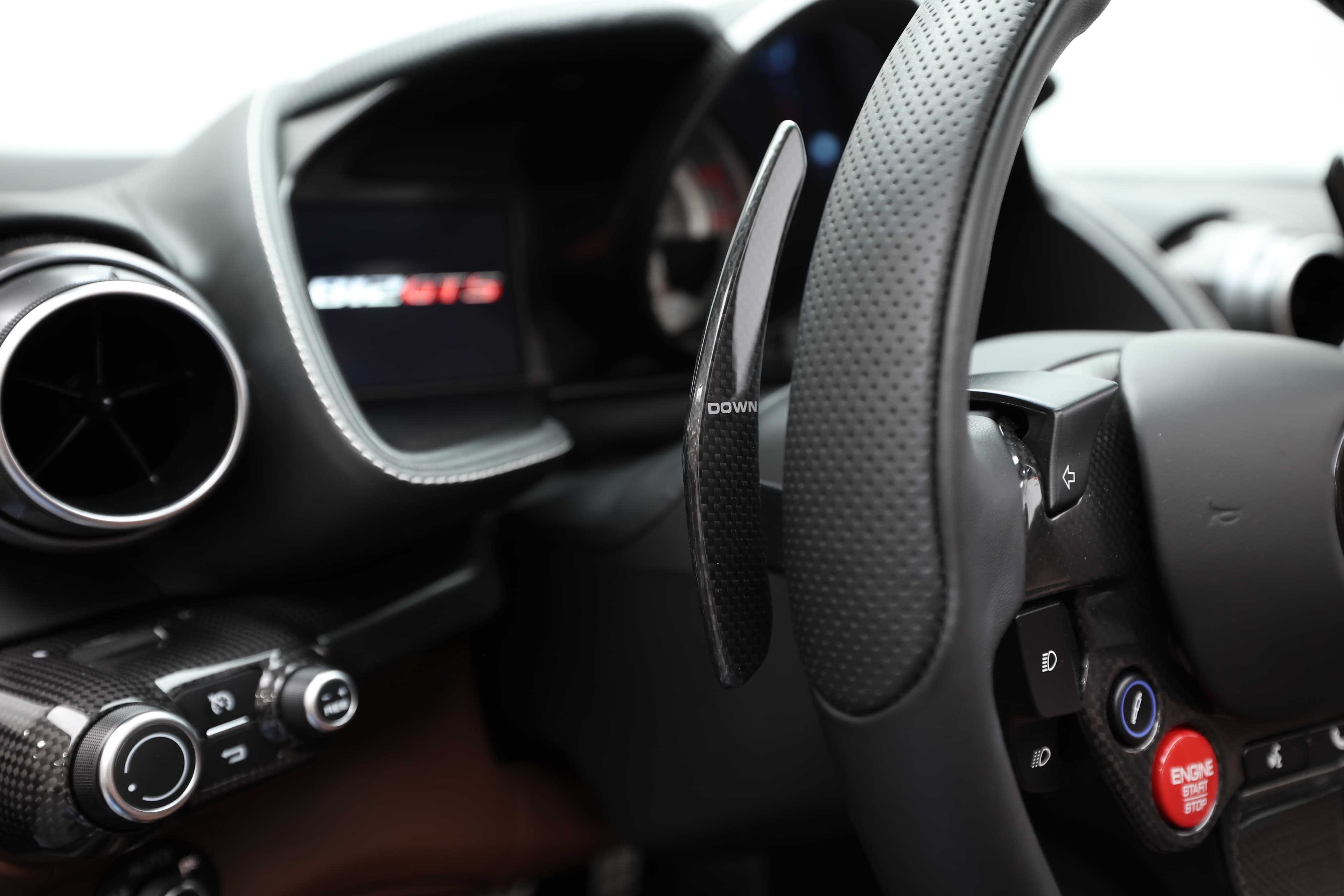 Voici un détail du tableau de bord de la Ferrari 812 GTS, mettant en avant le badge GTS et les commandes à portée de main. Ce design axé sur la performance allie esthétique et fonctionnalité, offrant une expérience de conduite immersive.