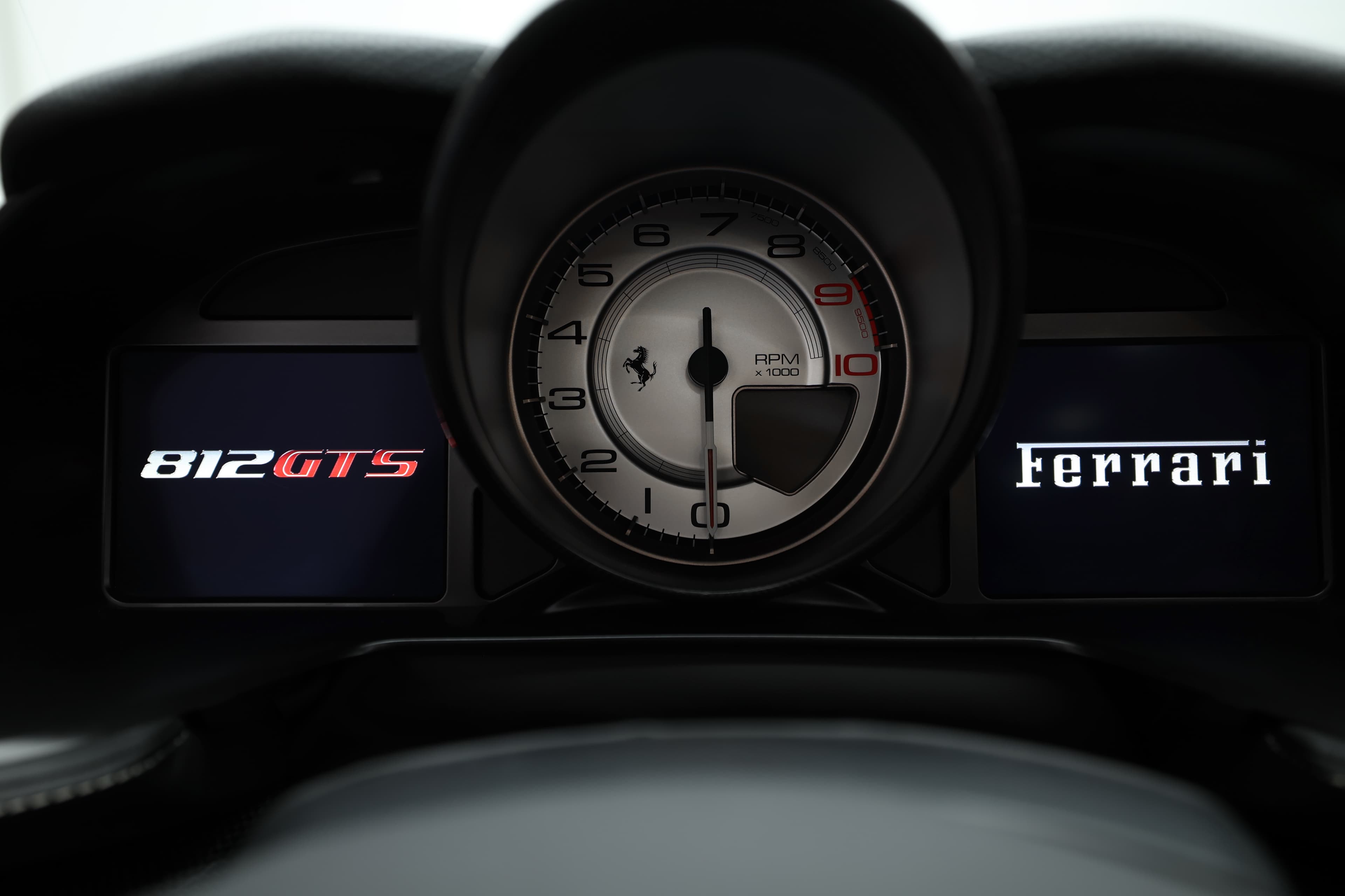 Voici un gros plan du compte-tours de la Ferrari 812 GTS, avec les inscriptions '812 GTS' et 'Ferrari'. Ce cadran, avec son design classique et sportif, offre une lecture claire des performances du moteur, renforçant l'expérience de conduite sur cette supercar.