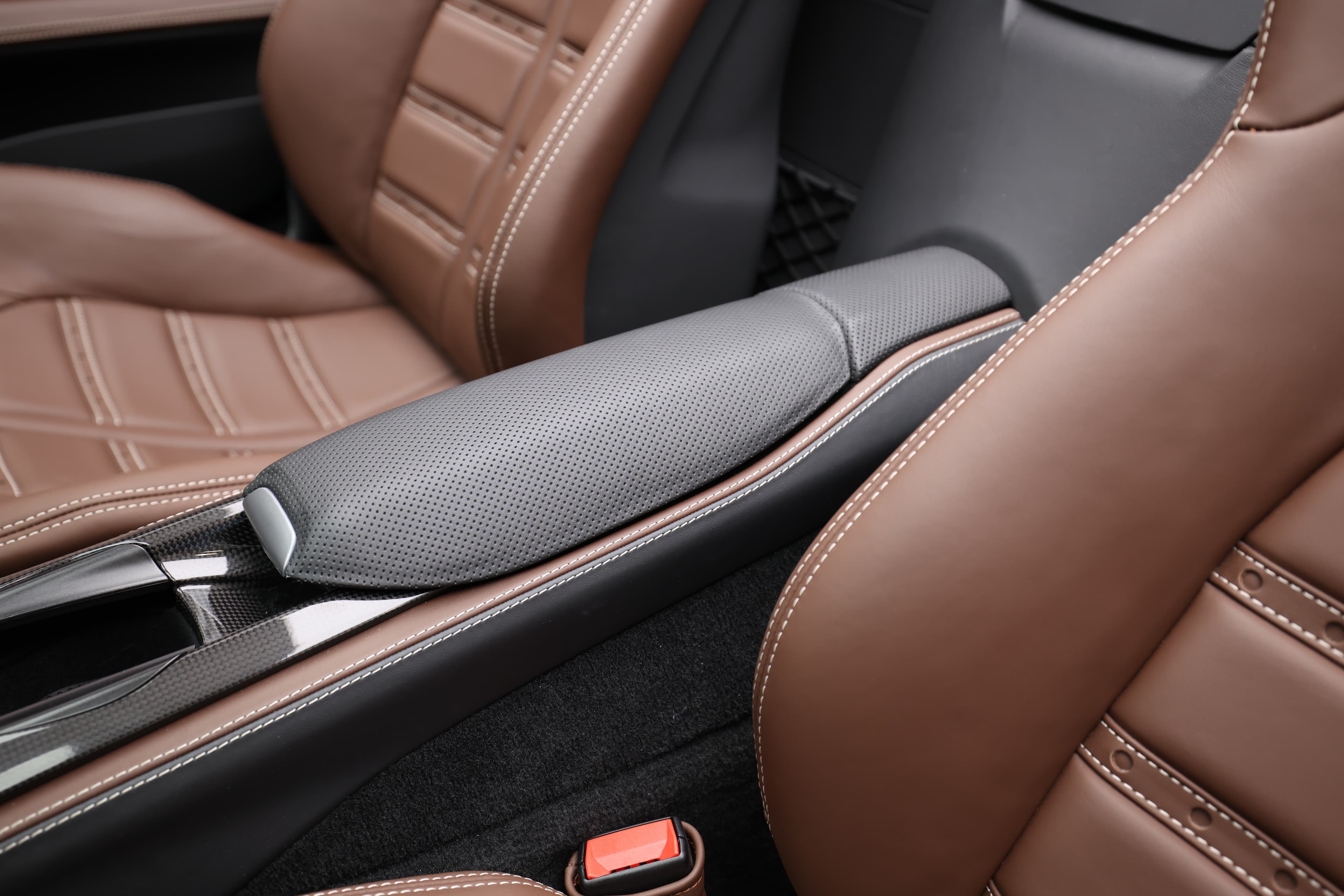 Voici un aperçu des sièges en cuir de la Ferrari 812 GTS, mettant en avant le rembourrage et la finition élégante. La combinaison de couleurs et le design ergonomique offrent à la fois confort et soutien lors de la conduite dynamique.