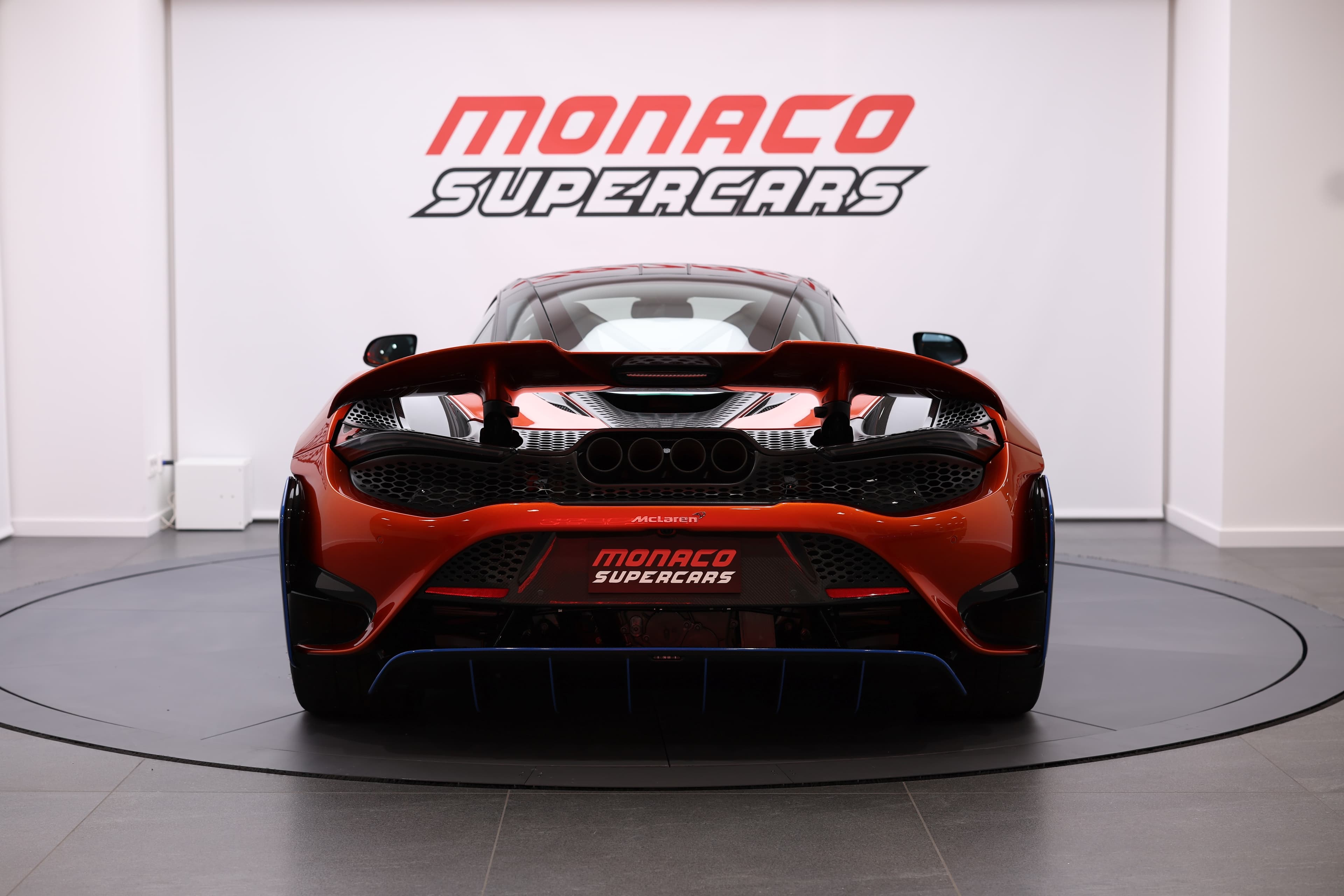 Vue arrière de la McLaren 765LT, mettant en avant son design aérodynamique agressif et ses lignes distinctives, soulignant la performance et l'élégance de cette supercar.