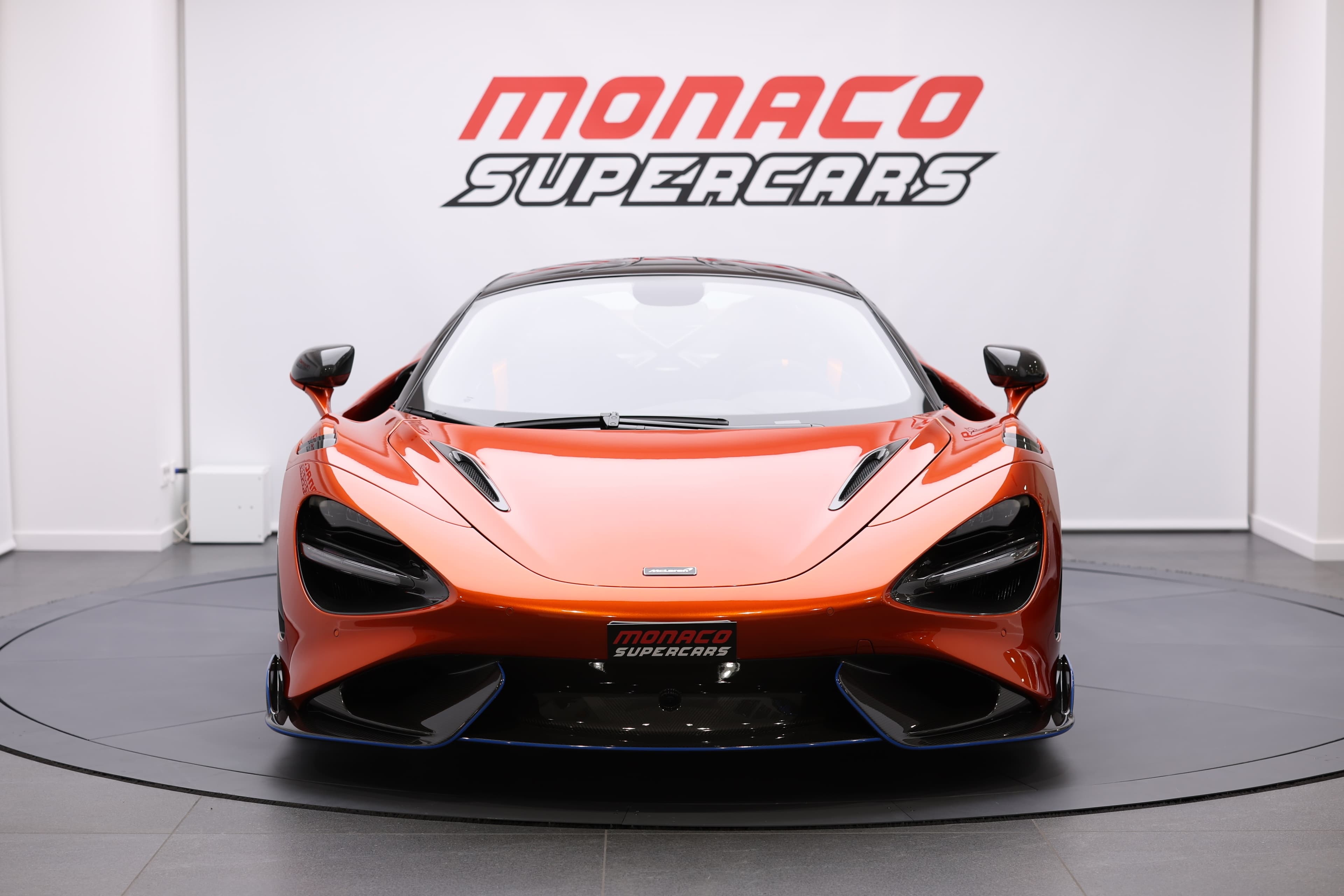 Vue frontale de la McLaren 765LT, mettant en avant son design audacieux et ses phares distinctifs, illustrant l'approche agressive et moderne de cette supercar.