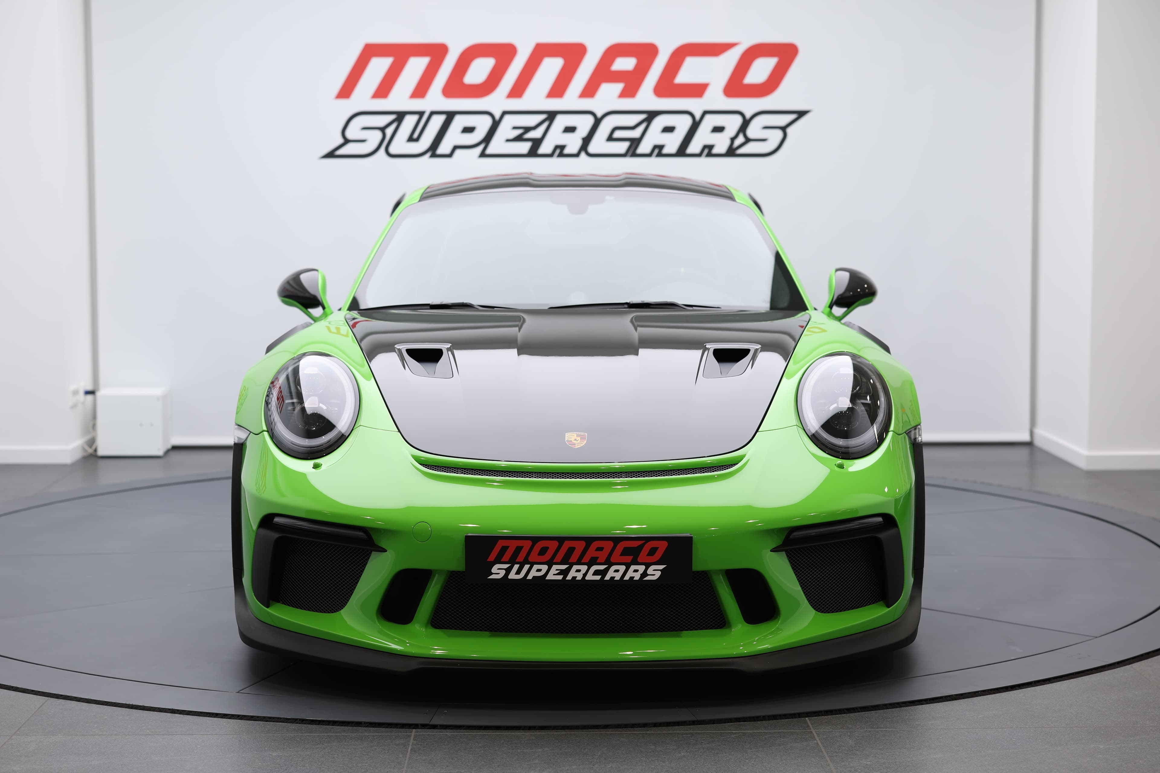 Vue avant d’une voiture de sport verte exposée chez Monaco Supercars, mettant en avant un design agressif et des performances d’exception.
