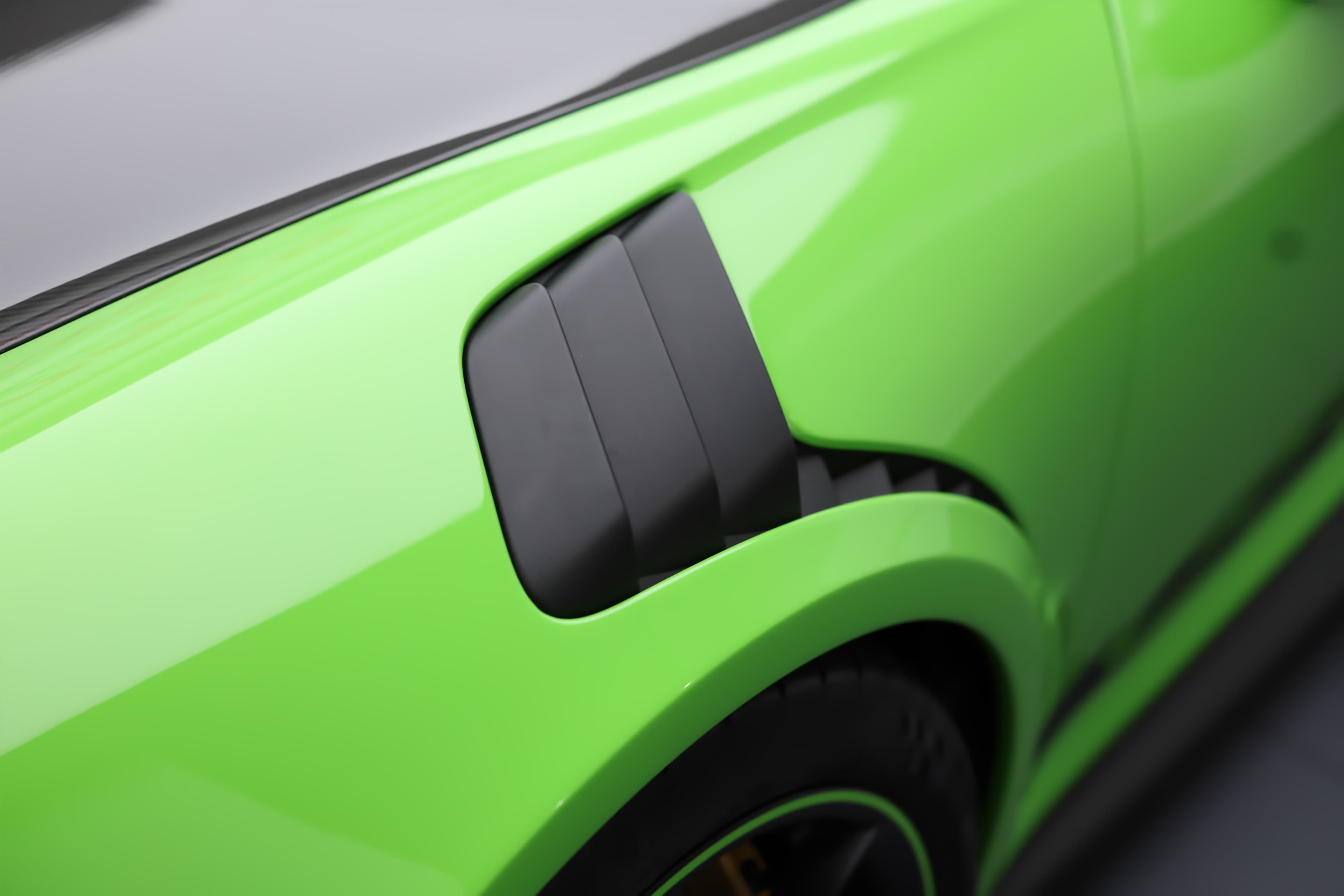 Détail de la Porsche 911 GT3 RS 991 verte mettant en avant les ouïes d’aération latérales spécifiques, conçues pour optimiser le refroidissement et les performances sur circuit.