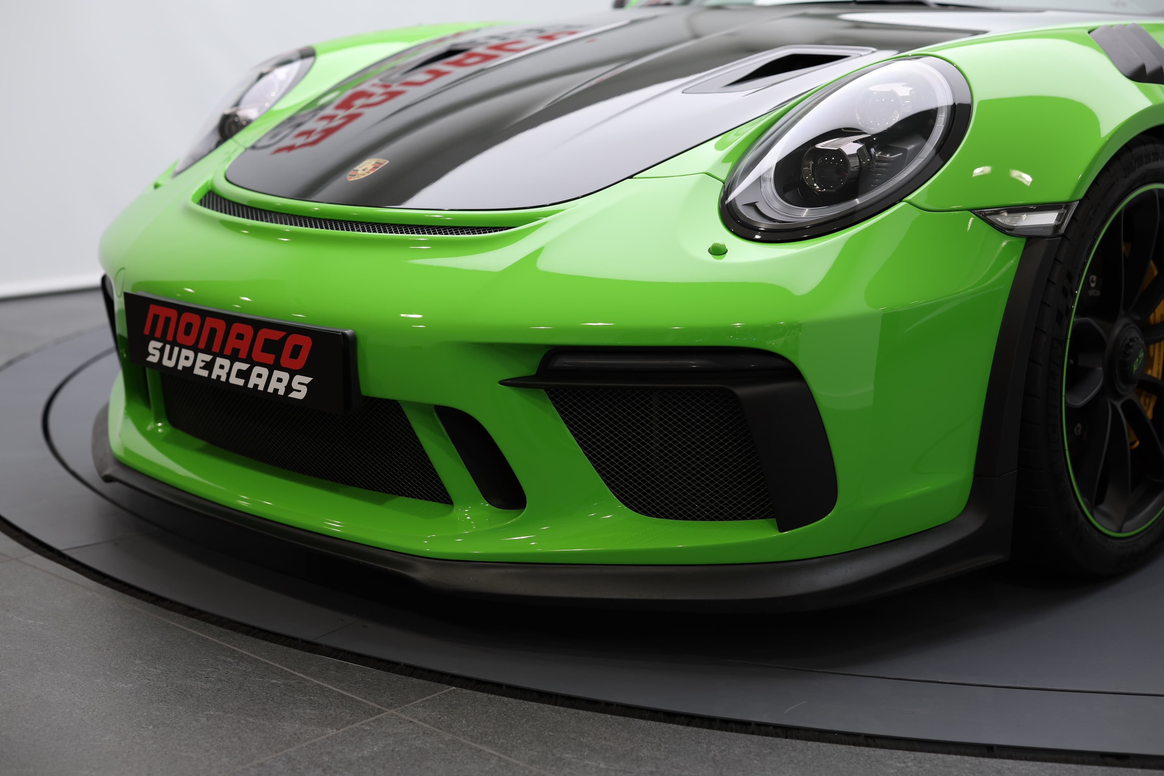 Détail du bouclier avant de la Porsche 911 GT3 RS 991 verte, mettant en évidence les larges entrées d’air et l’aérodynamique agressive pensée pour la performance sur circuit.