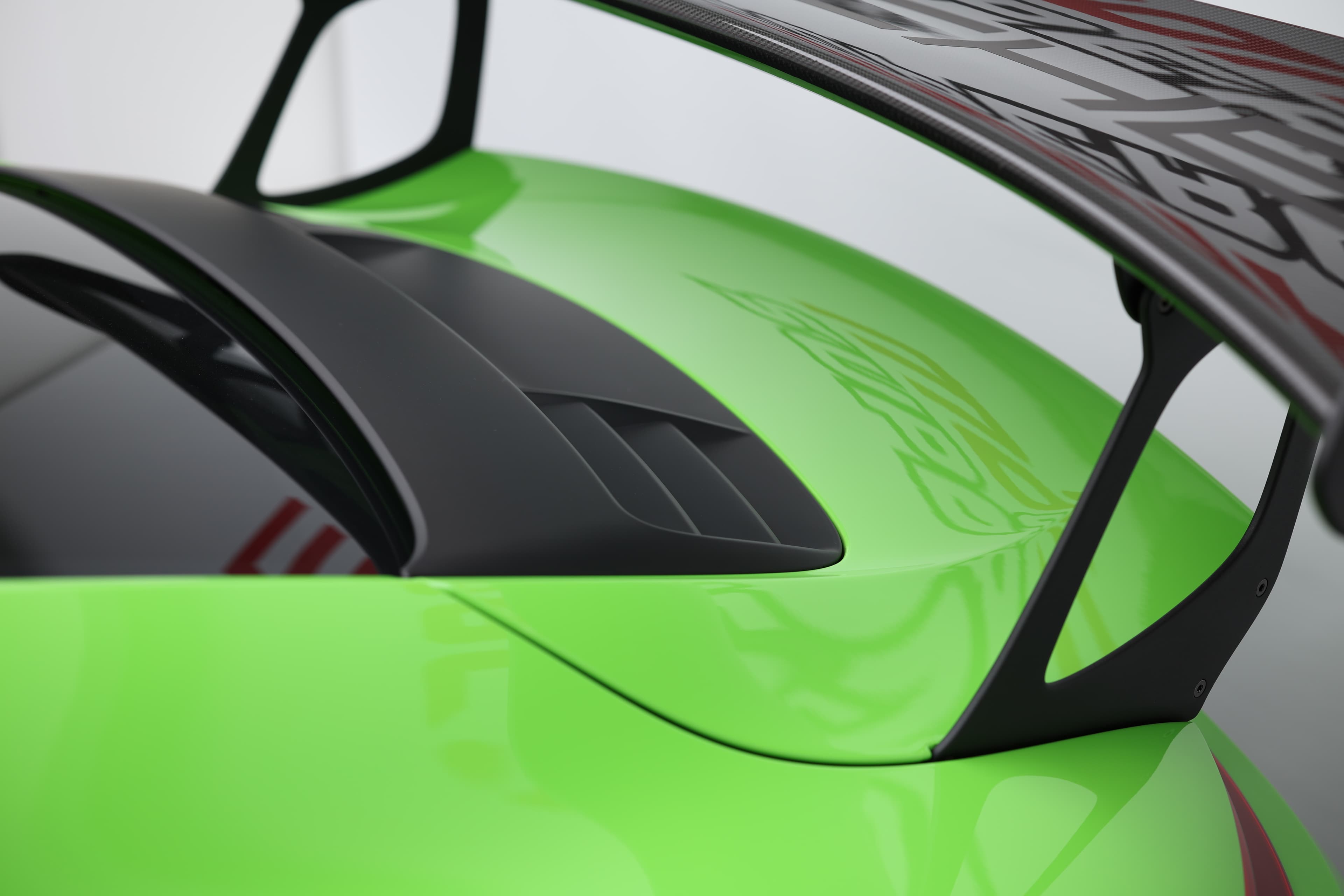 Détail de l’arrière de la Porsche 911 GT3 RS 991 verte mettant en avant les ouïes de ventilation moteur et l’intégration de l’aileron pour un appui aérodynamique maximal.