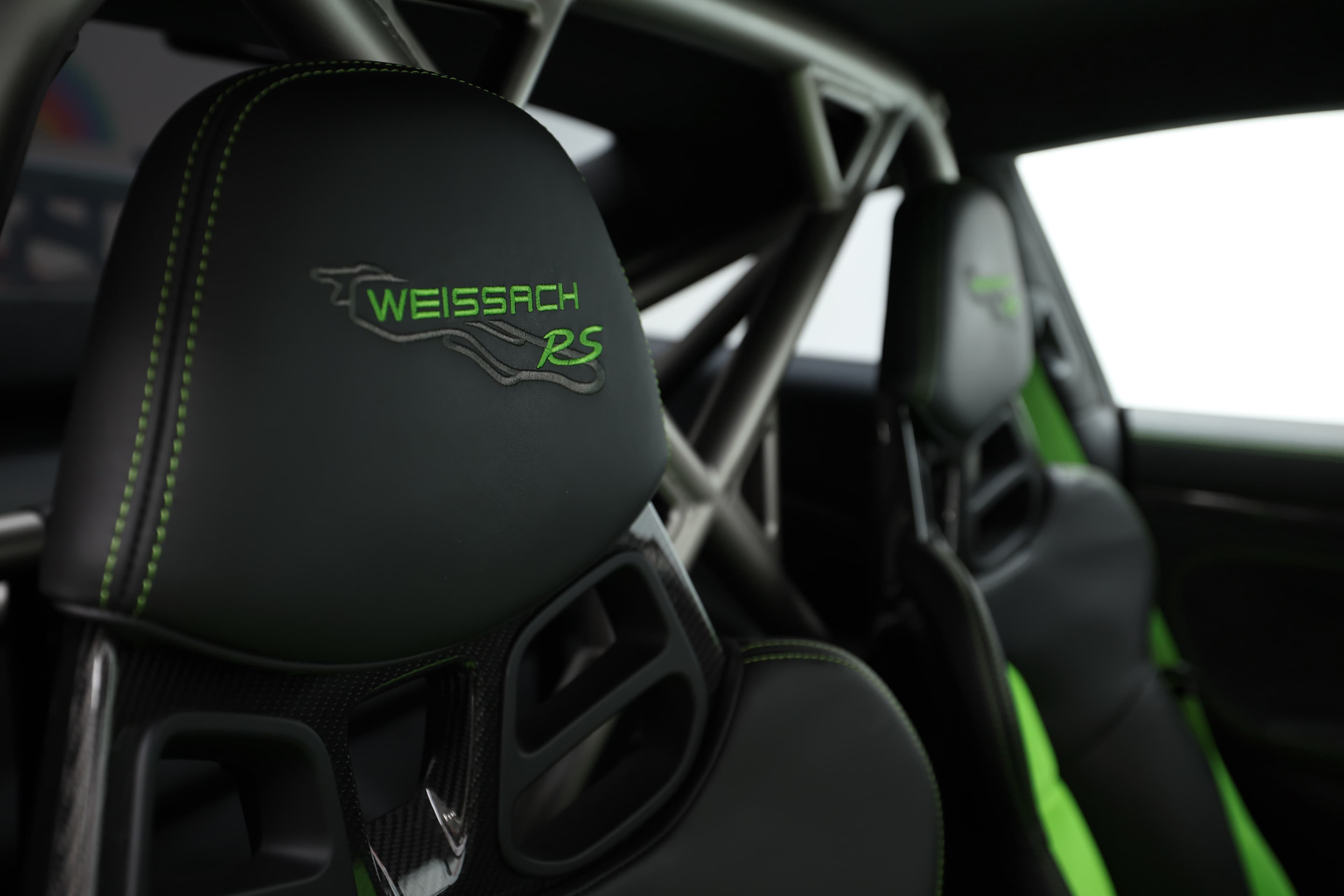Les sièges baquets de la Porsche GT3 RS, ornés du logo "Weissach RS" et de surpiqûres vertes, offrent un mélange parfait de confort et de soutien, tout en célébrant l'héritage de performance de la marque.