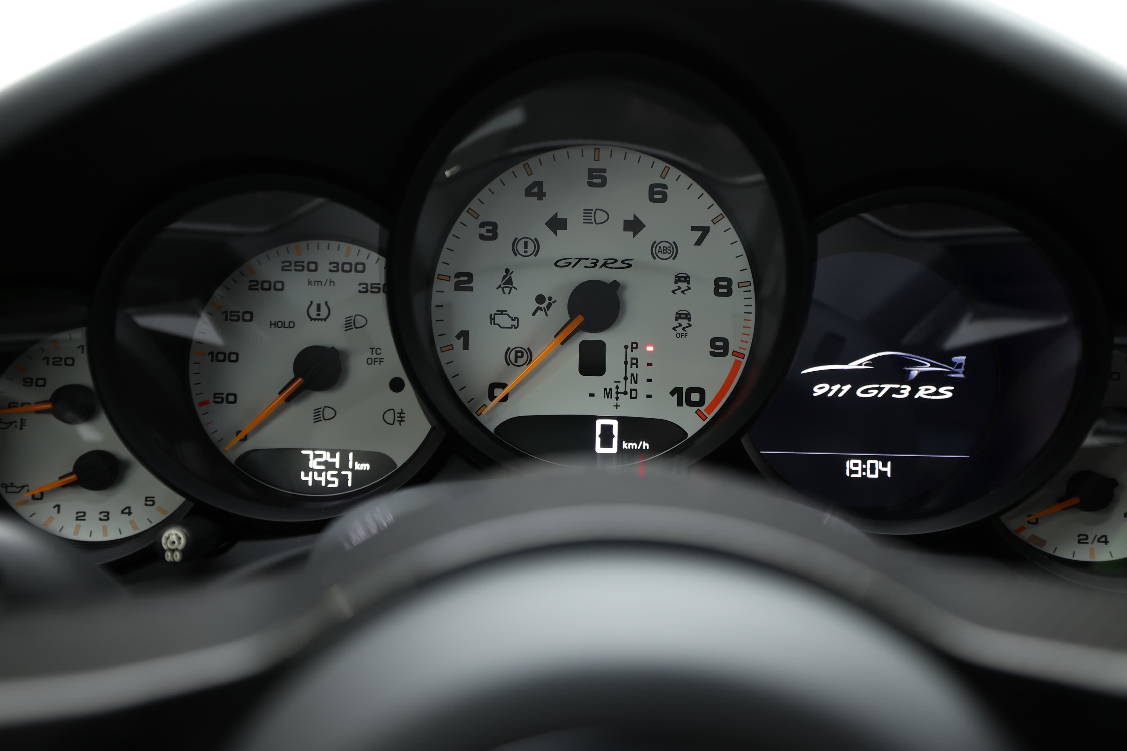 Le tableau de bord de la Porsche GT3 RS est un mélange de technologie et de sportivité, avec des compteurs numériques et analogiques bien disposés. Les indicateurs clairs et colorés permettent un suivi rapide des performances, renforçant l'expérience de conduite dynamique.