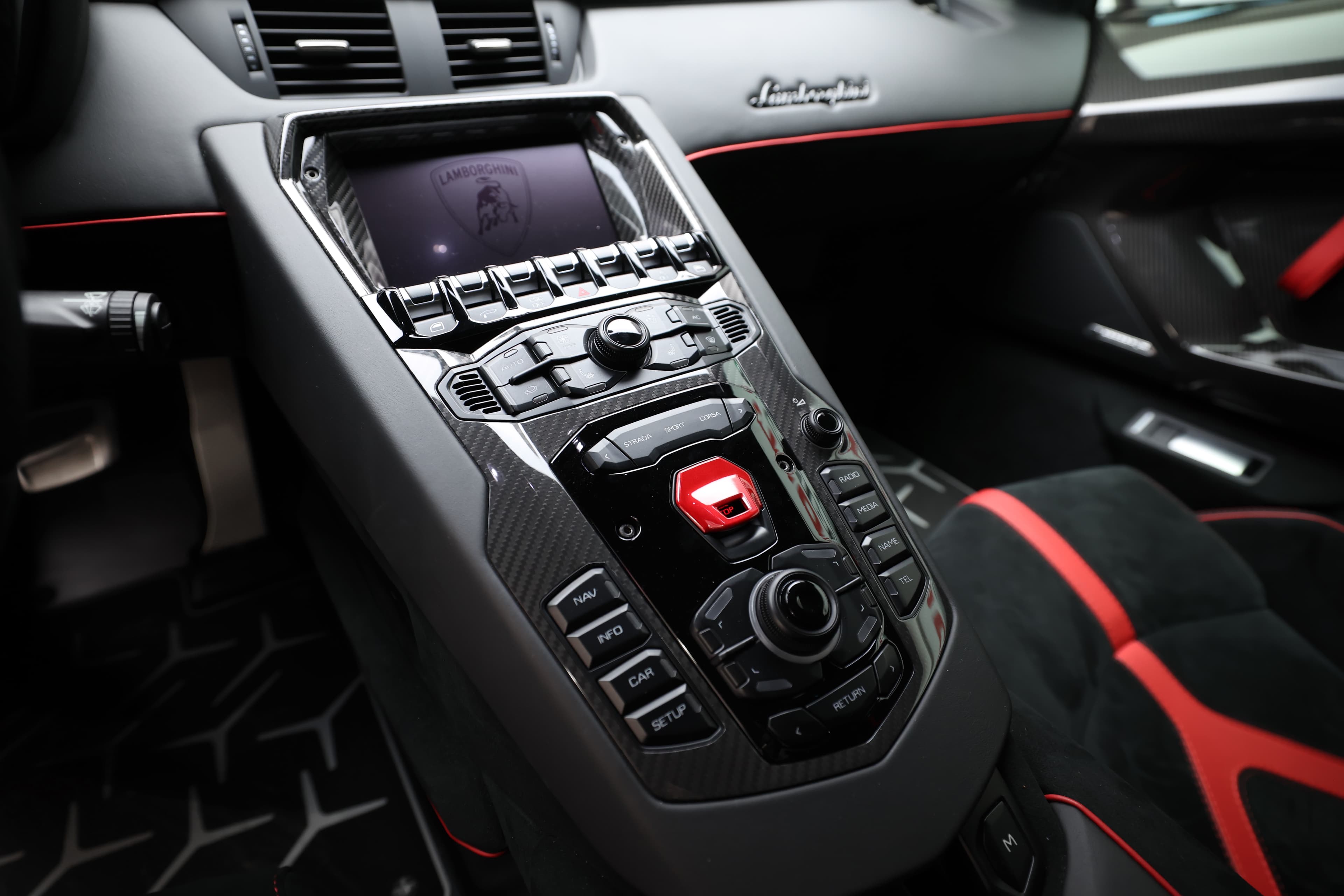 Approfondissez votre regard sur le centre de contrôle de la Lamborghini Aventador SV, où chaque bouton et écran est soigneusement intégré dans un design en carbone. L'interface utilisateur est faite pour optimiser l'accès aux fonctionnalités, offrant une expérience de conduite moderne et dynamique