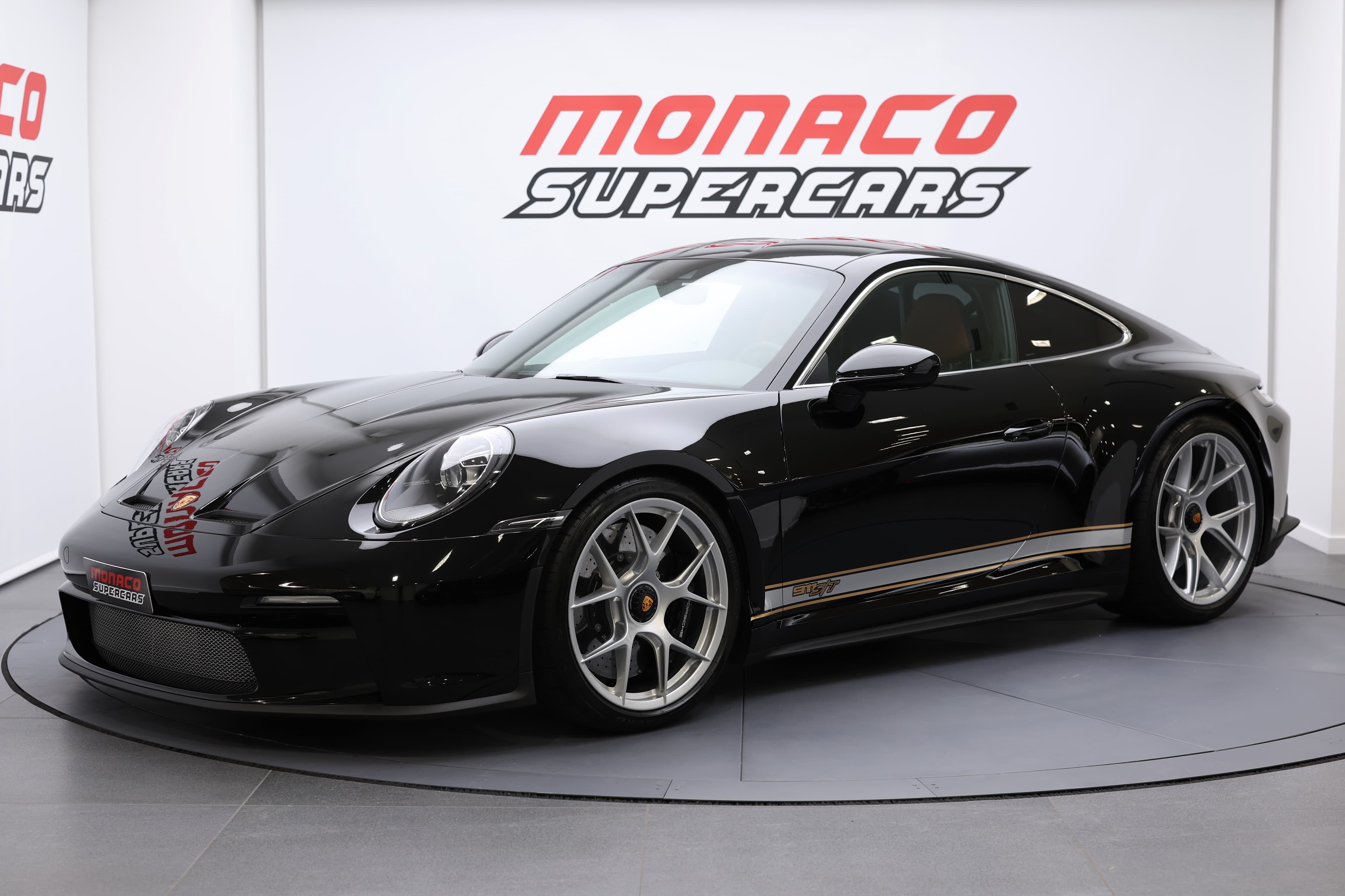  Porsche 911 élégante, vue légèrement de côté, présentée à Monaco Supercars, incarnant le luxe et la puissance, séduisant les amateurs d'automobiles.