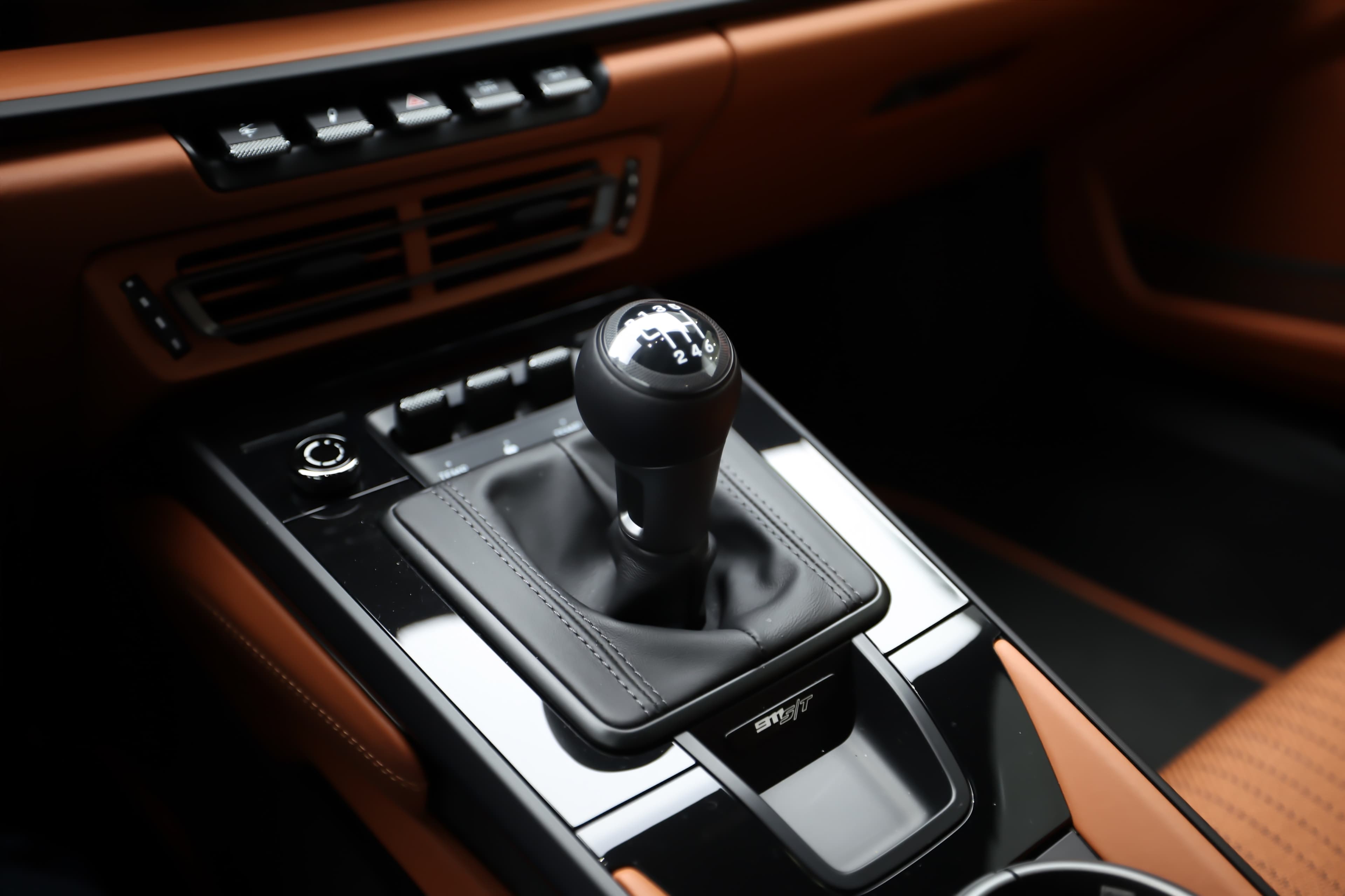 Détail du levier de vitesses de la Porsche 911. Le design est élégant et sportif, avec un pommeau en métal qui ajoute une touche premium. L'ensemble est bien intégré dans l'habitacle, offrant une expérience de conduite engageante et dynamique. Il
