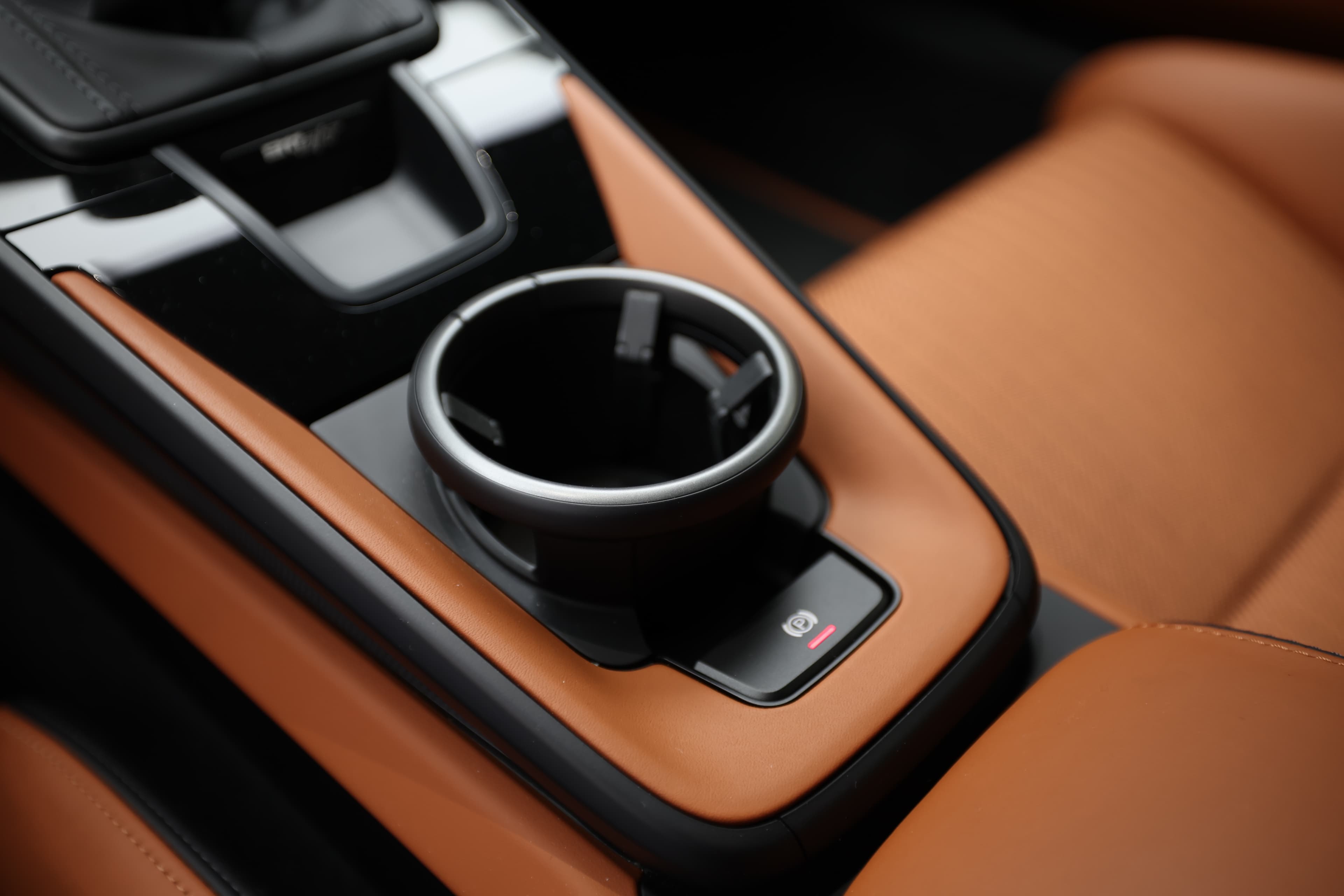 Détail du porte-gobelet dans la Porsche 911. Son design est à la fois pratique et esthétique, s'intégrant parfaitement dans l'ensemble du tableau de bord. La finition en métal souligne le souci du détail tout en ajoutant une touche de luxe à l'intérieur.