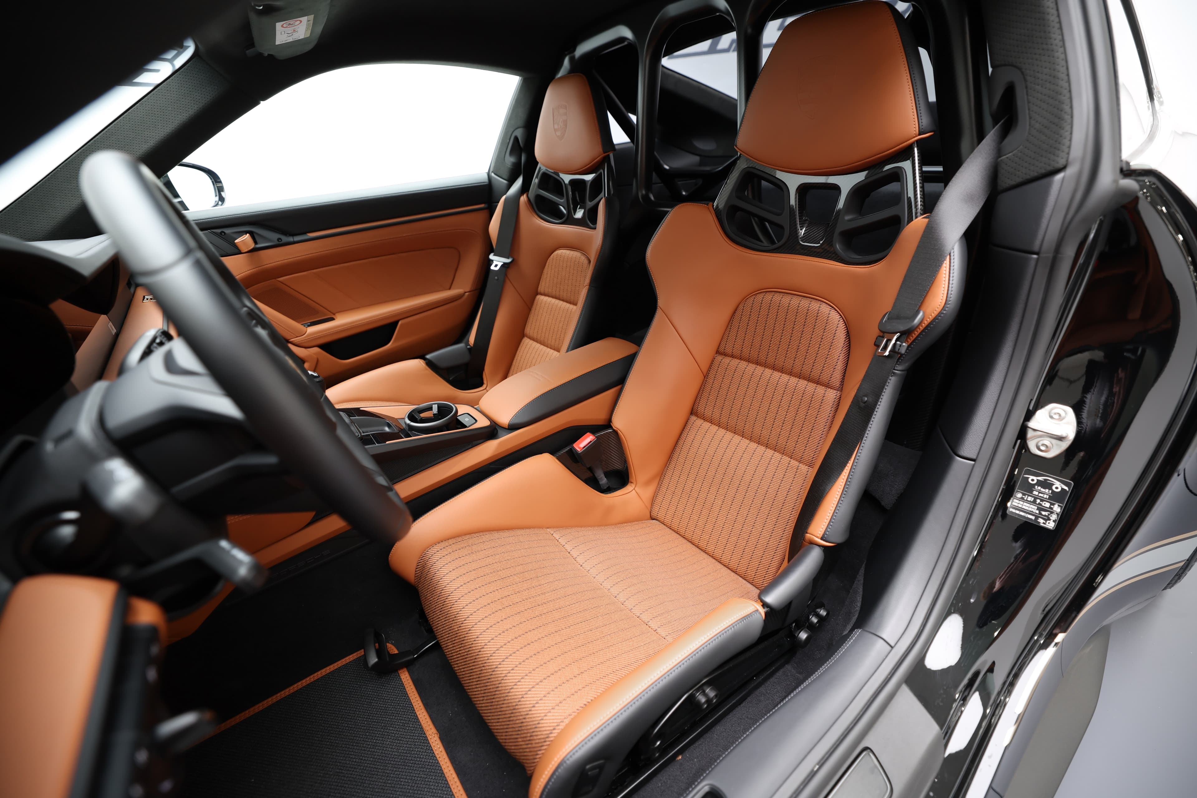 Plongez dans l'intérieur dynamique d'une voiture de sport, avec des sièges en cuir orange à motifs et un design moderne, alliant confort et performance pour une expérience de conduite inoubliable.