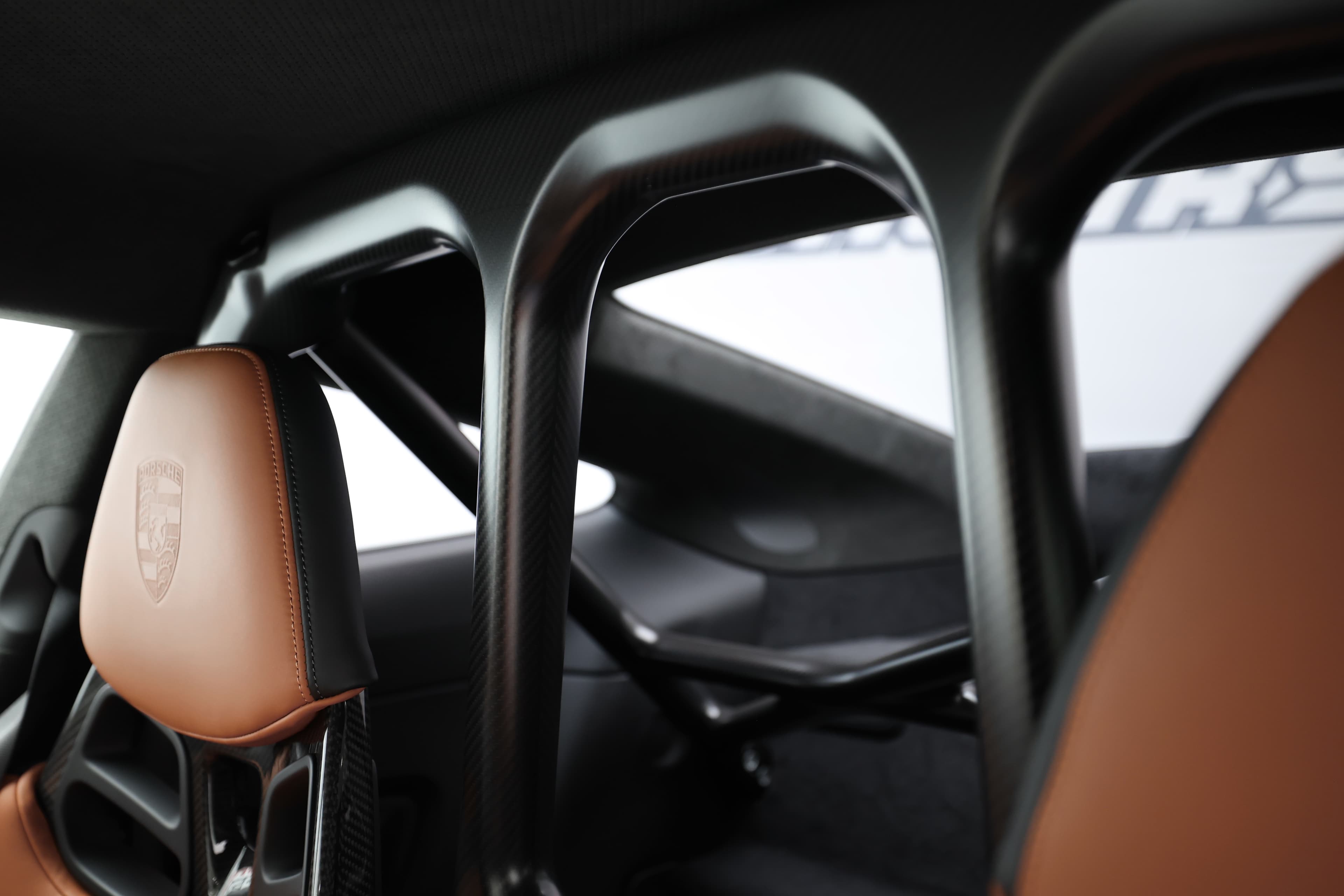 Détail de la structure interne de sécurité, mettant en valeur les sièges sportifs et les éléments en carbone.